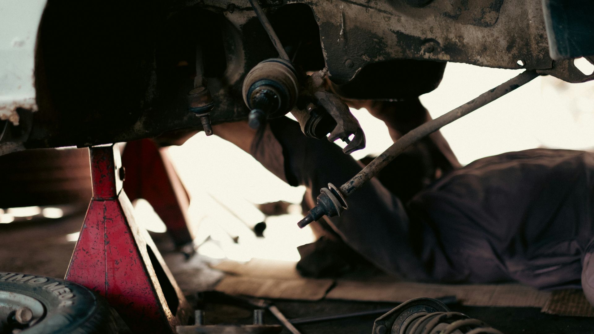 a man working on a car under a vehicle