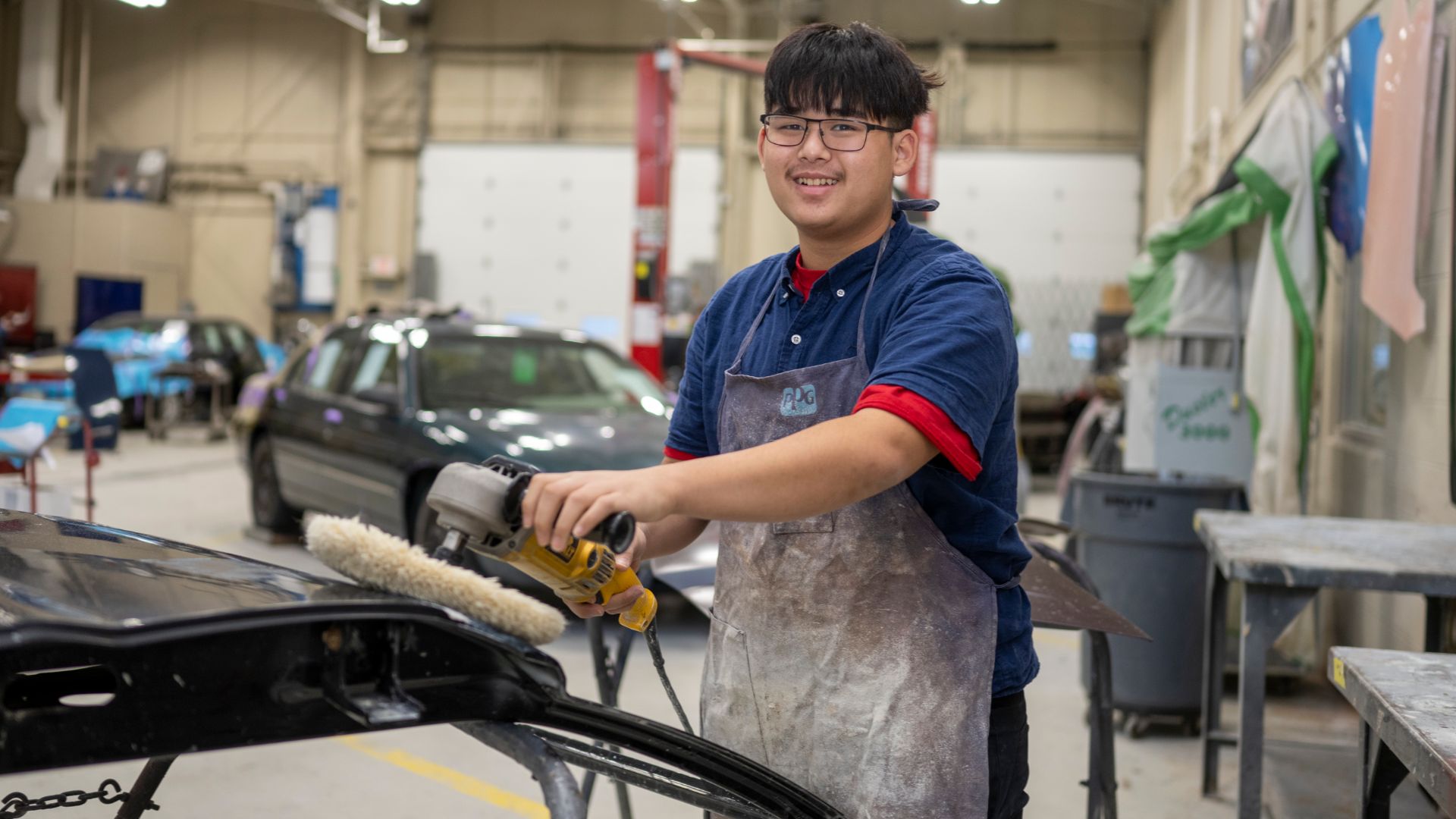 An auto collision student buffing out a car door