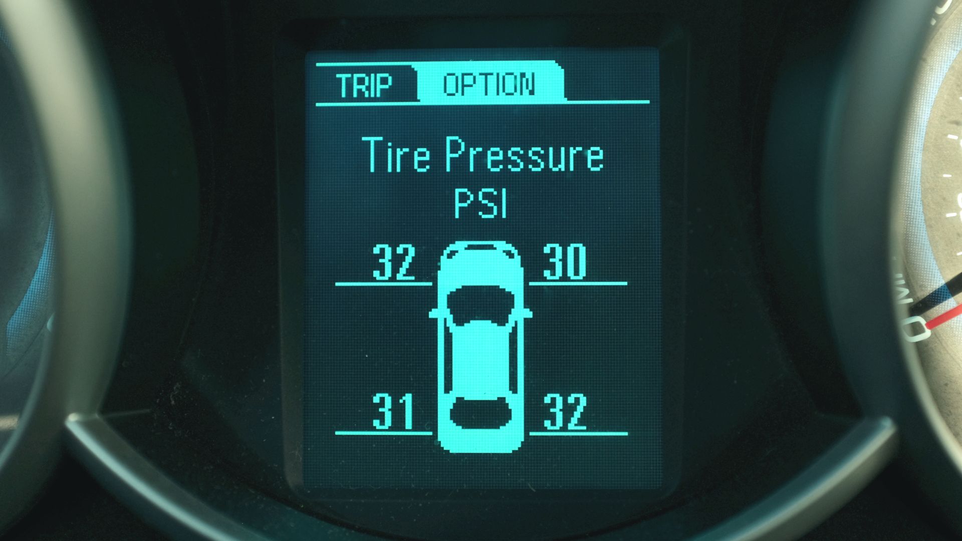 Electronic Driver Information Center (DIC) in a 2013 Chevrolet Cruze displaying pressure measurements reported by the Tire Pressure Monitoring System (TPMS). Measured pressure for each tire is displayed in pounds per square inch (PSI). Pictograph of vehic