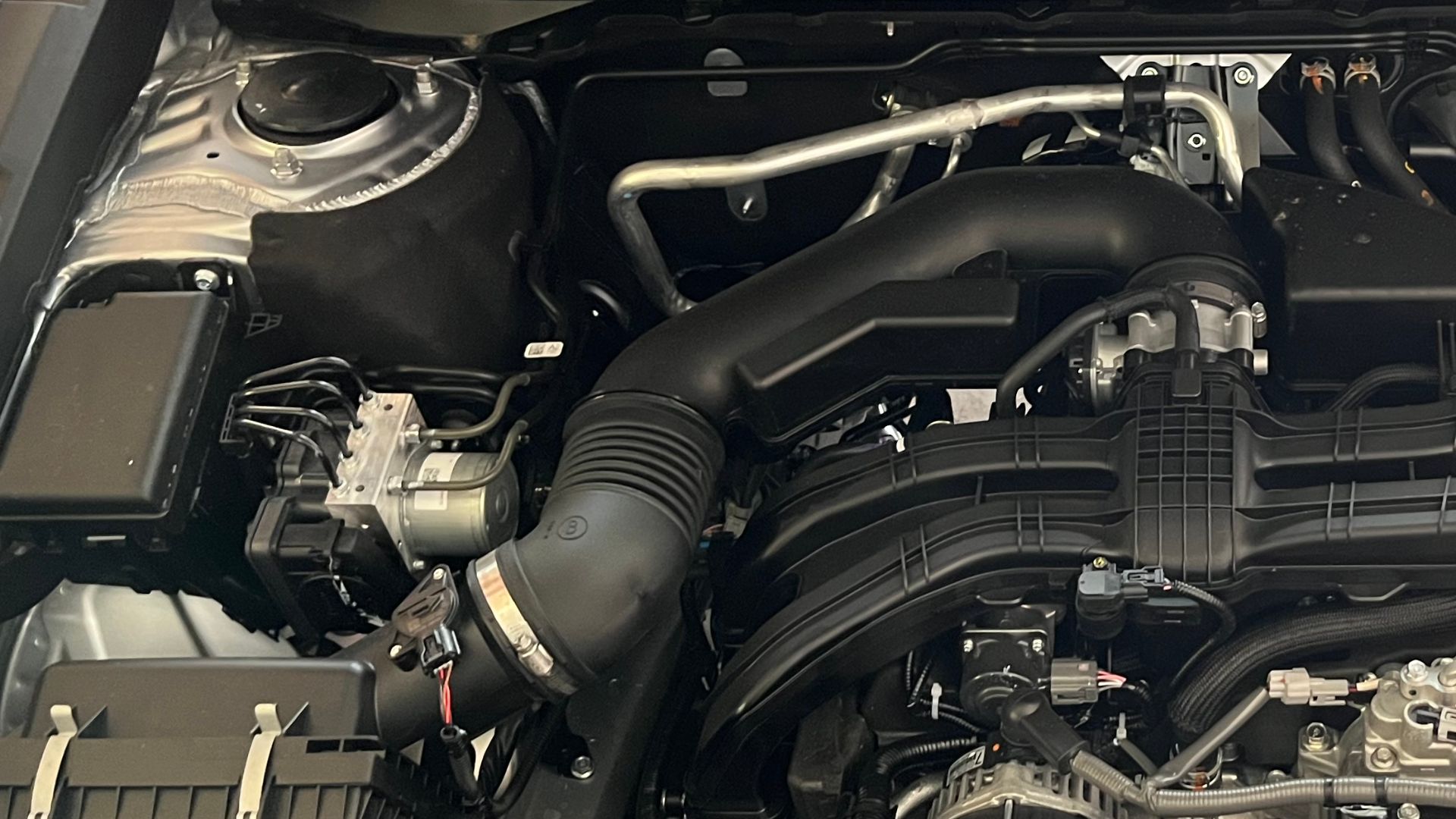 Engine bay under the hood of a USDM 2023 Subaru Outback Limited equipped with the FB25D, a 2.5 liter, 4 cylinder boxer engine. Imaged in Castle Pines, Colorado, USA.
