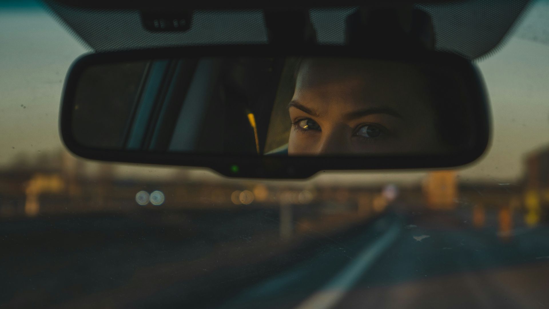 a woman's reflection in a rear view mirror