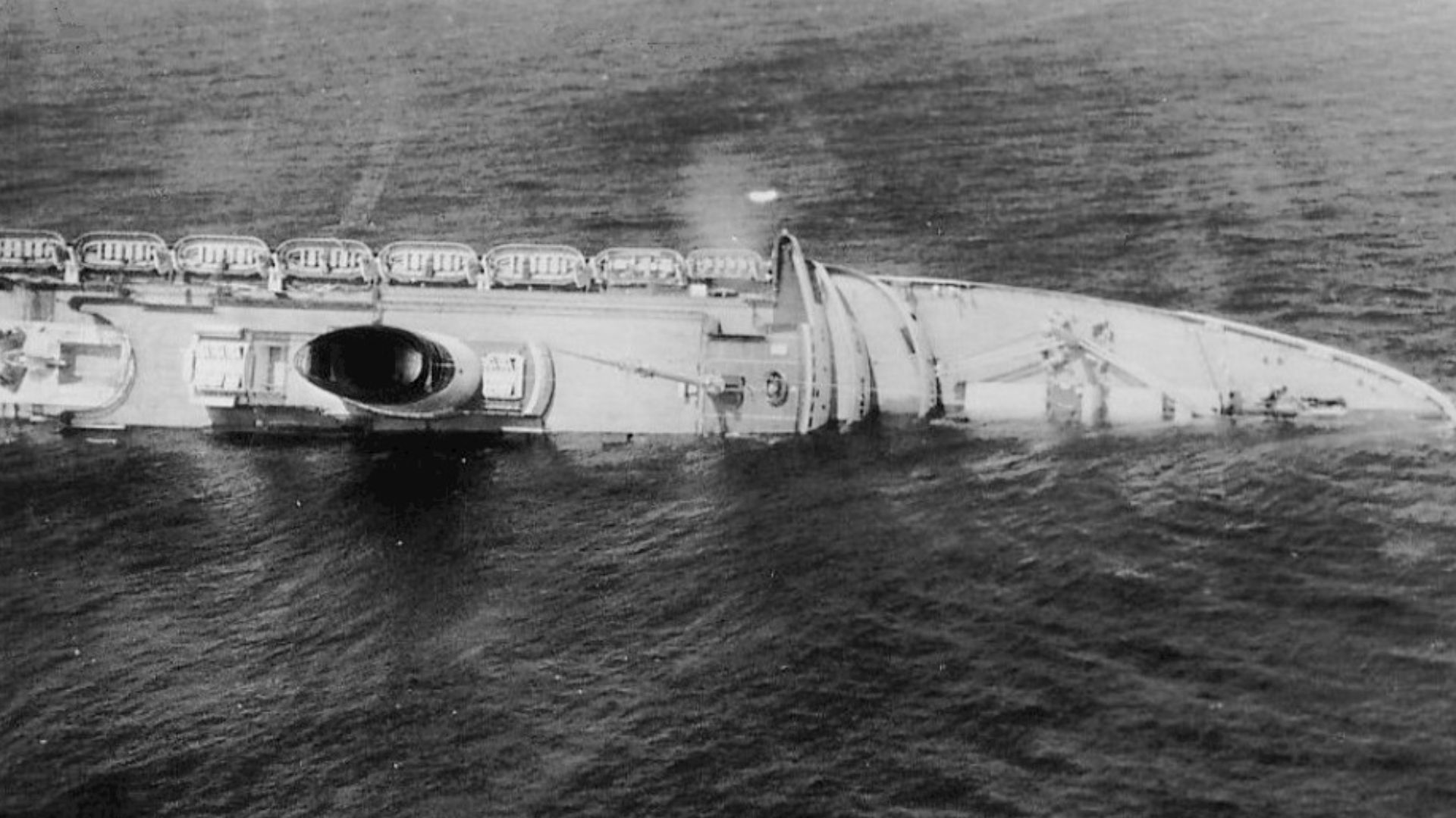 Photo of the Andrea Doria as the liner begins to sink after a collision with the Swedish vessel Stockholm off Nantucket Island, Massachusetts in July 1956.  Note that there are shadows in the photo because they were taken from the window of a plane.