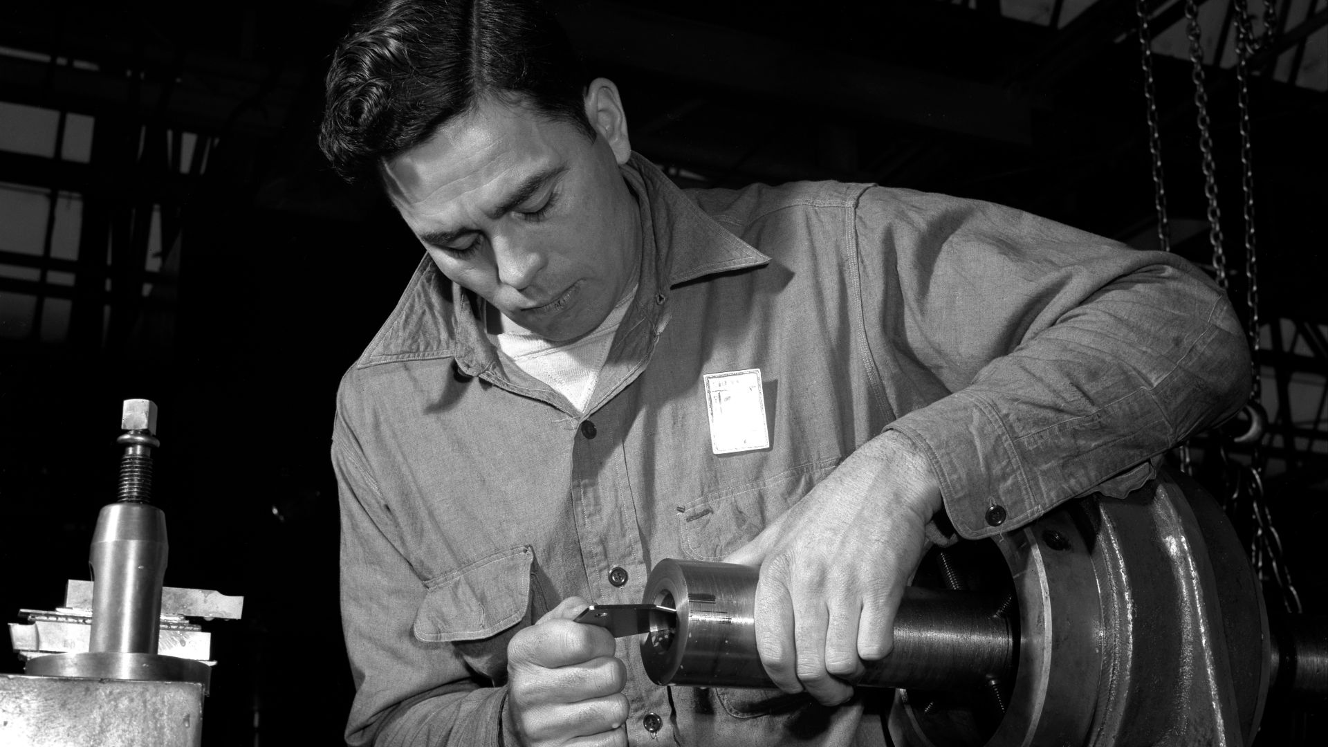 To ensure maximum efficiency, every 40 mm. anti-aircraft gun barrel made in this former automobile plant is checked and double checked. Here an inspector is examining the size of the bore in an army barrel. Chrysler Corporation, Highland Park, Detroit