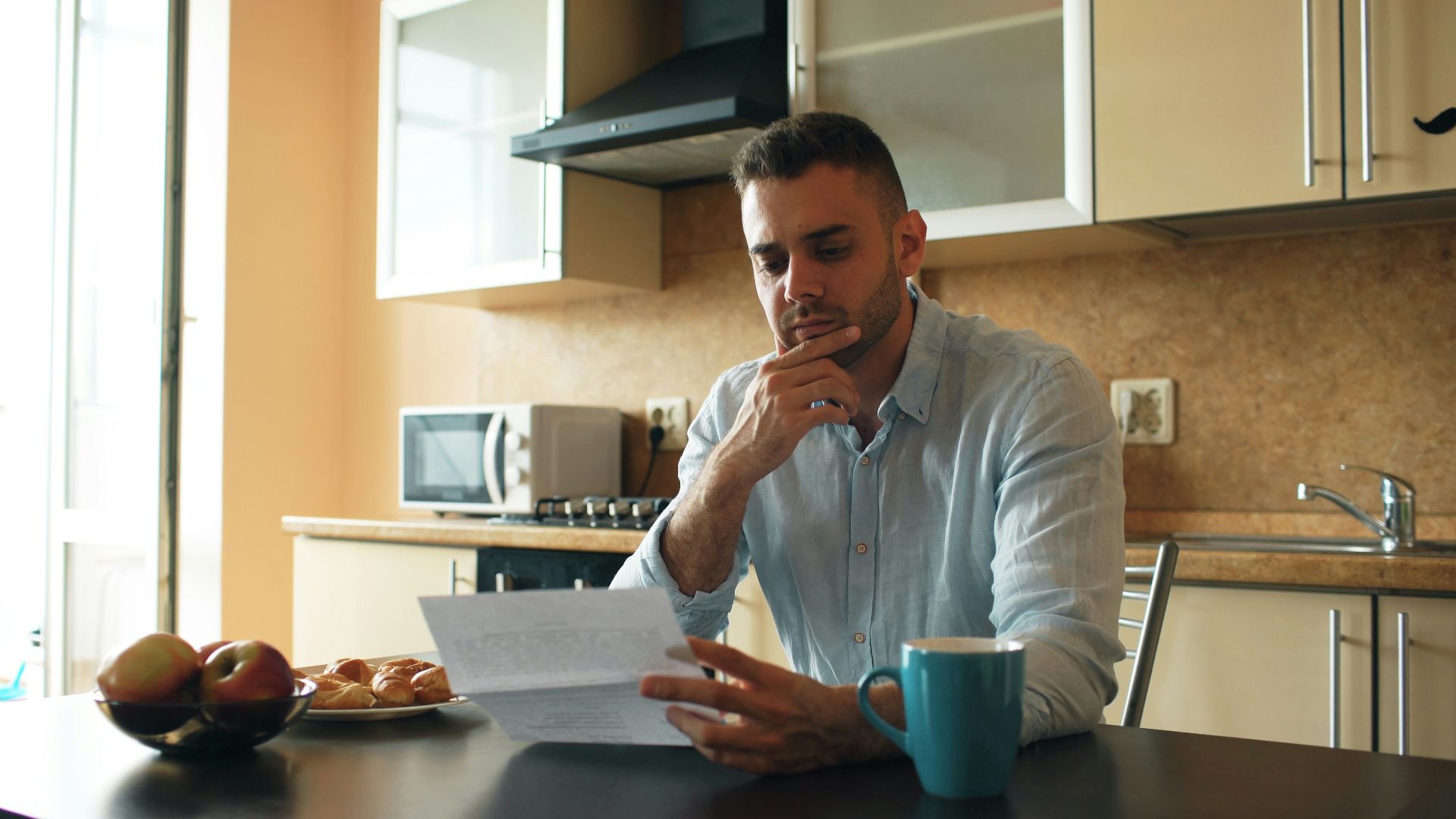 Man reading a document in a kitchen