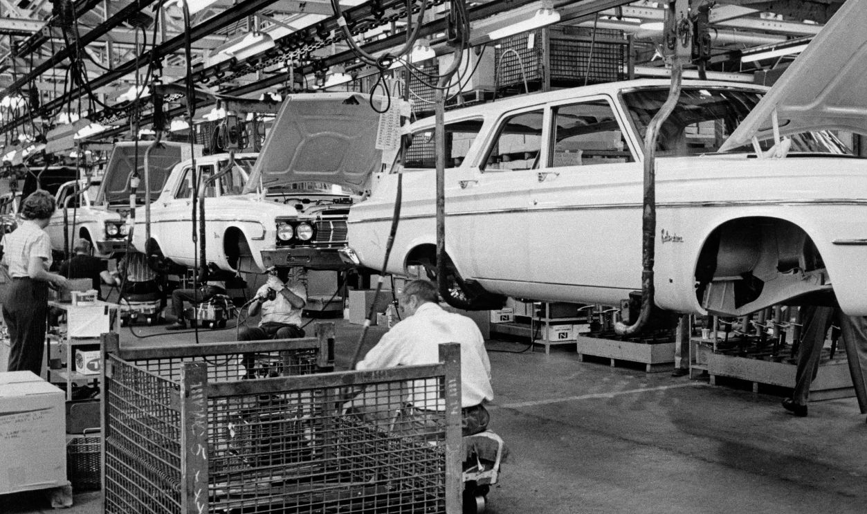 CHRYSLER ASSEMBLY LINE WITH CAR BODIES ELEVATED FOR EMPLOYEES TO WORK UNDERNEATH
