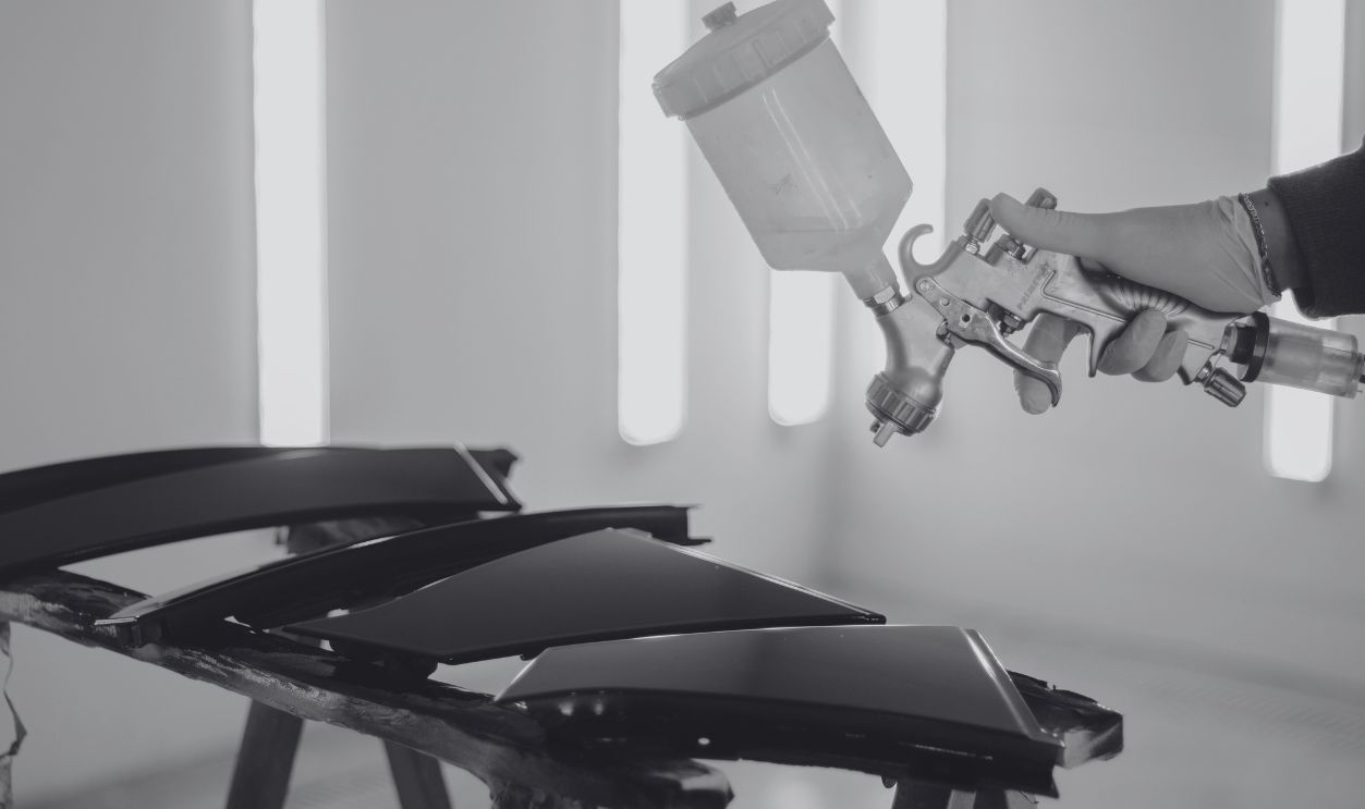 Close-up of car parts being spray-painted