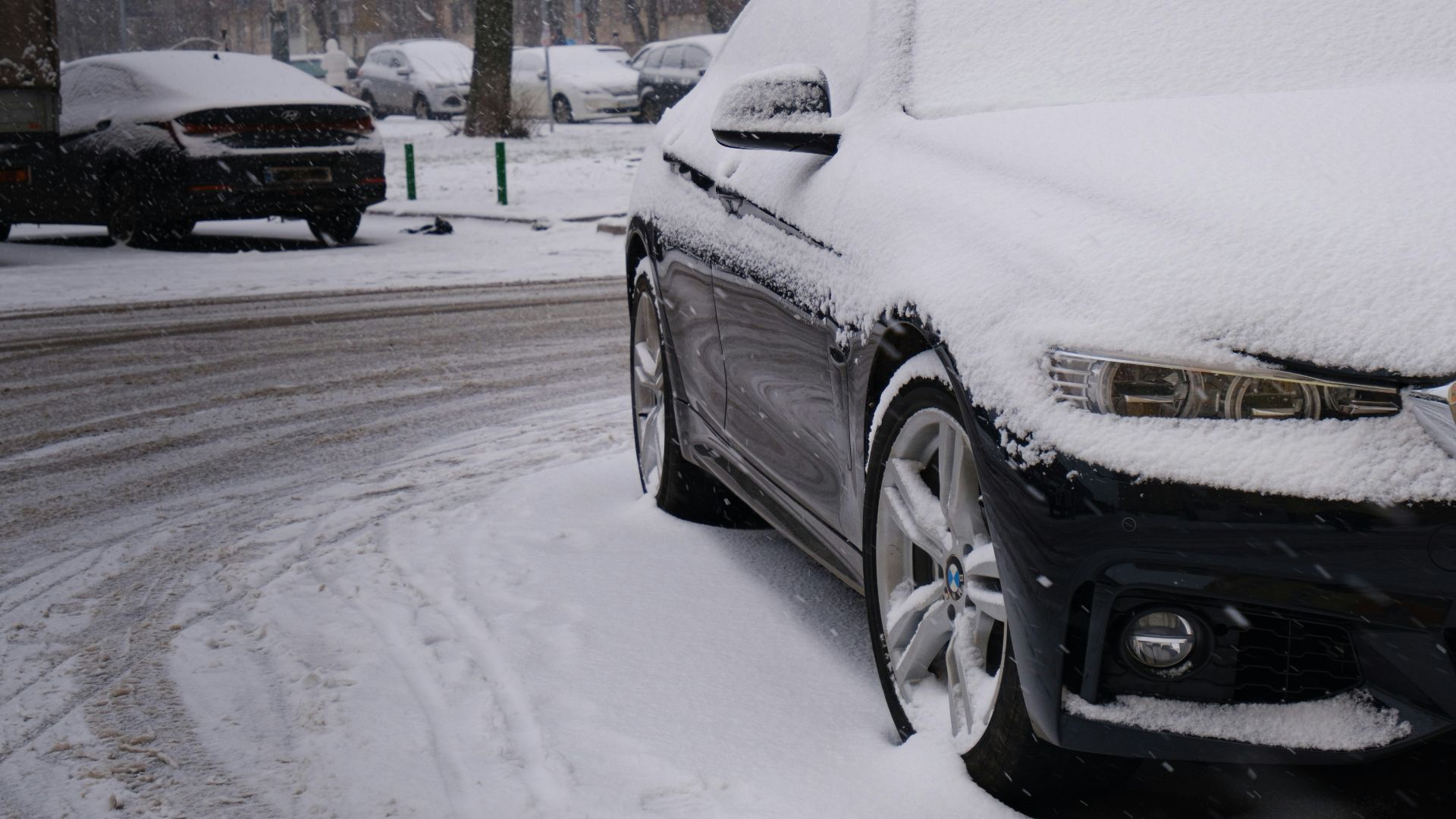 a car covered in snow on a snowy street