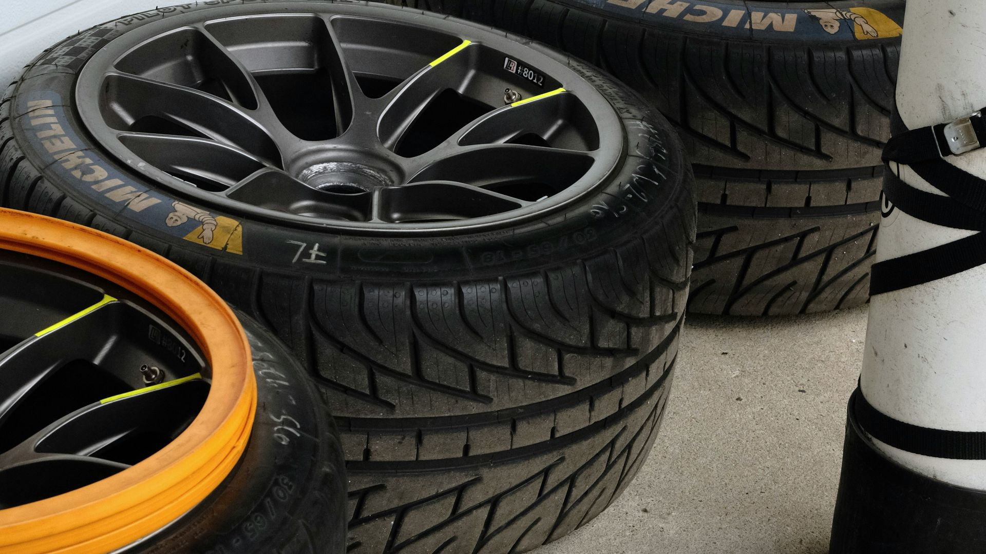 Racing tires and oxygen tank by white wall