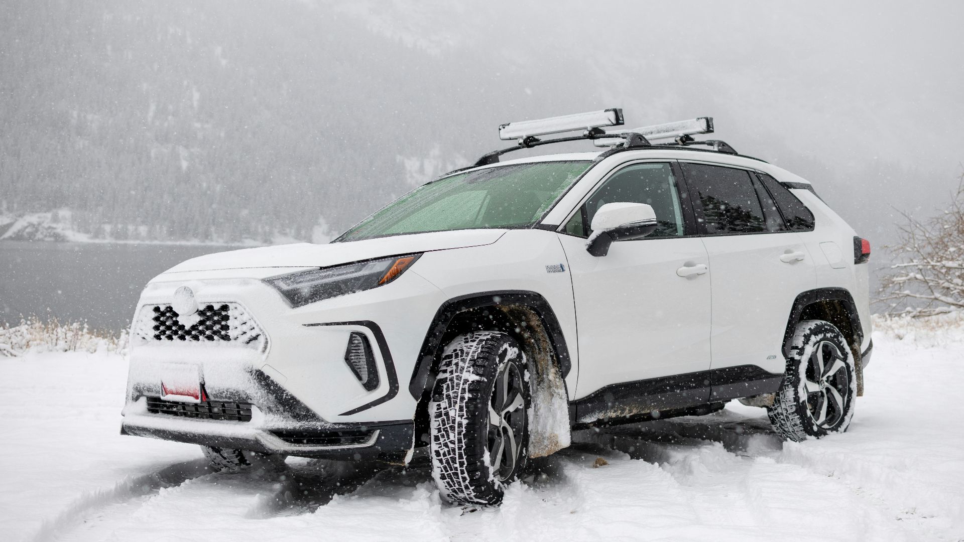 a white suv is parked in the snow