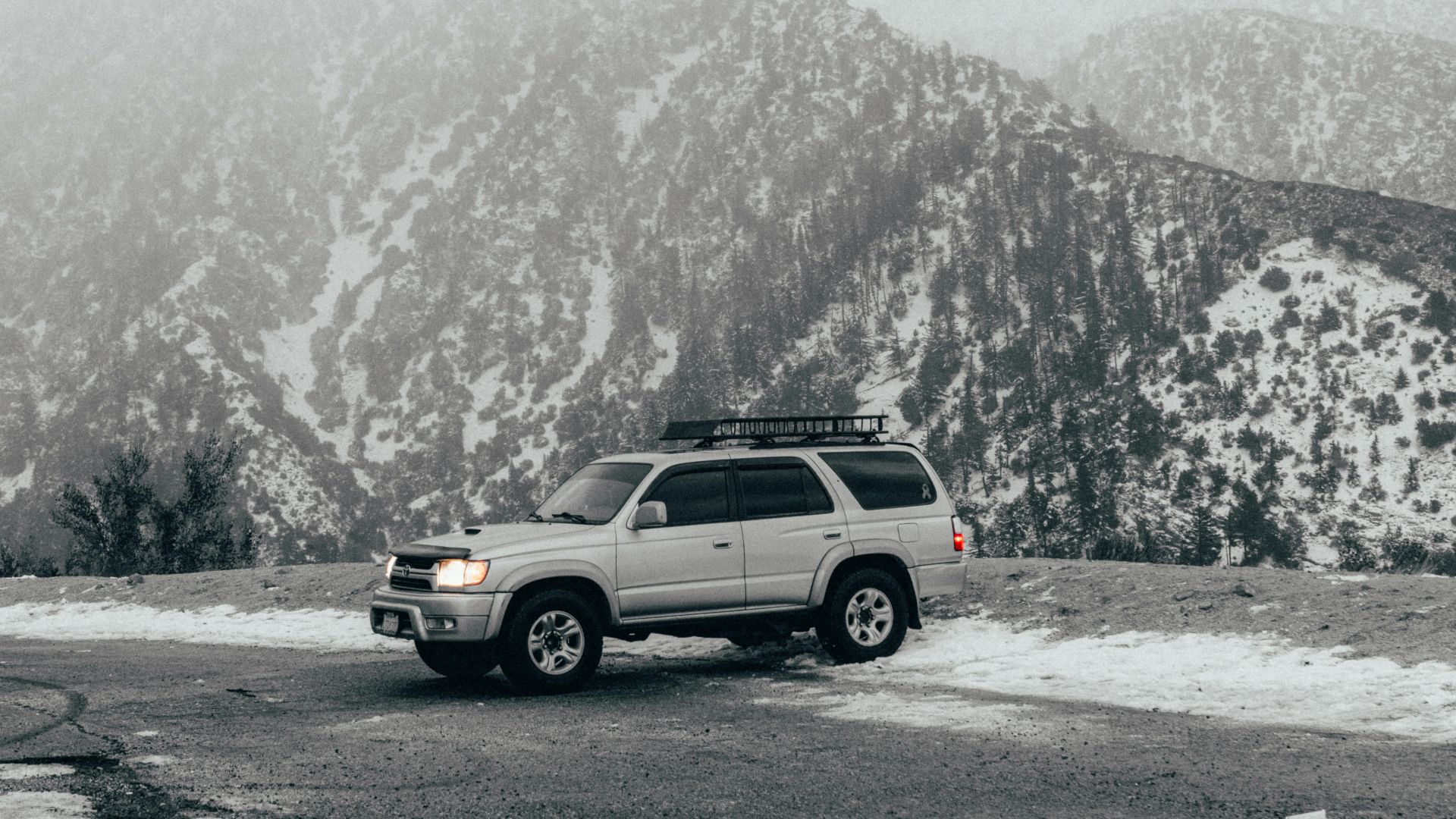 a car parked in a parking lot in front of a mountain