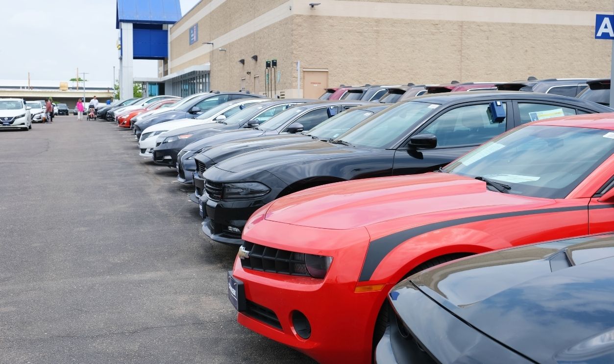 Retail parking lot outside the CarMax used cars dealership building with a row of parked vehicles: Colorado, USA - May 24, 2025