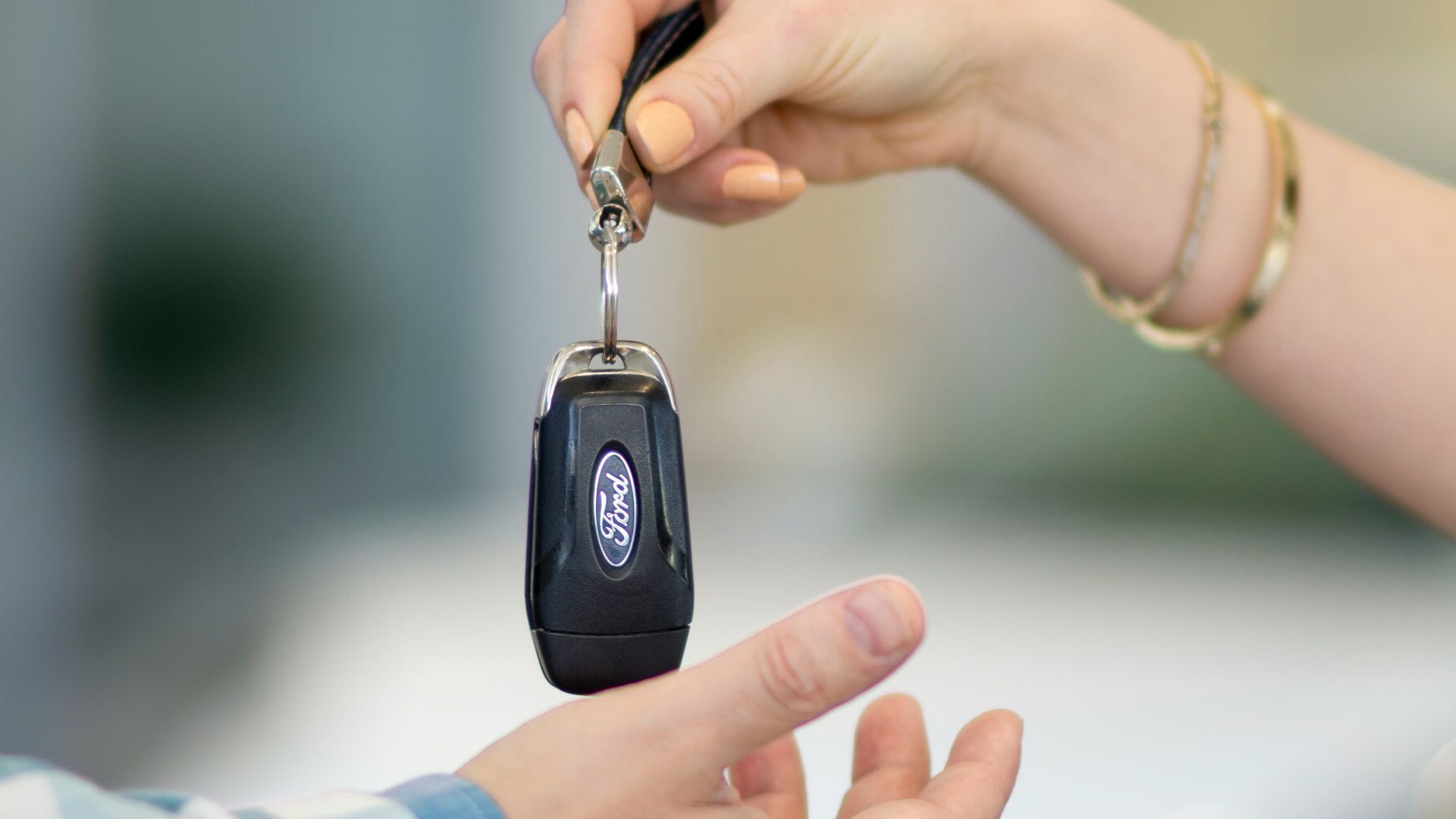 A person handing a car key to another person
