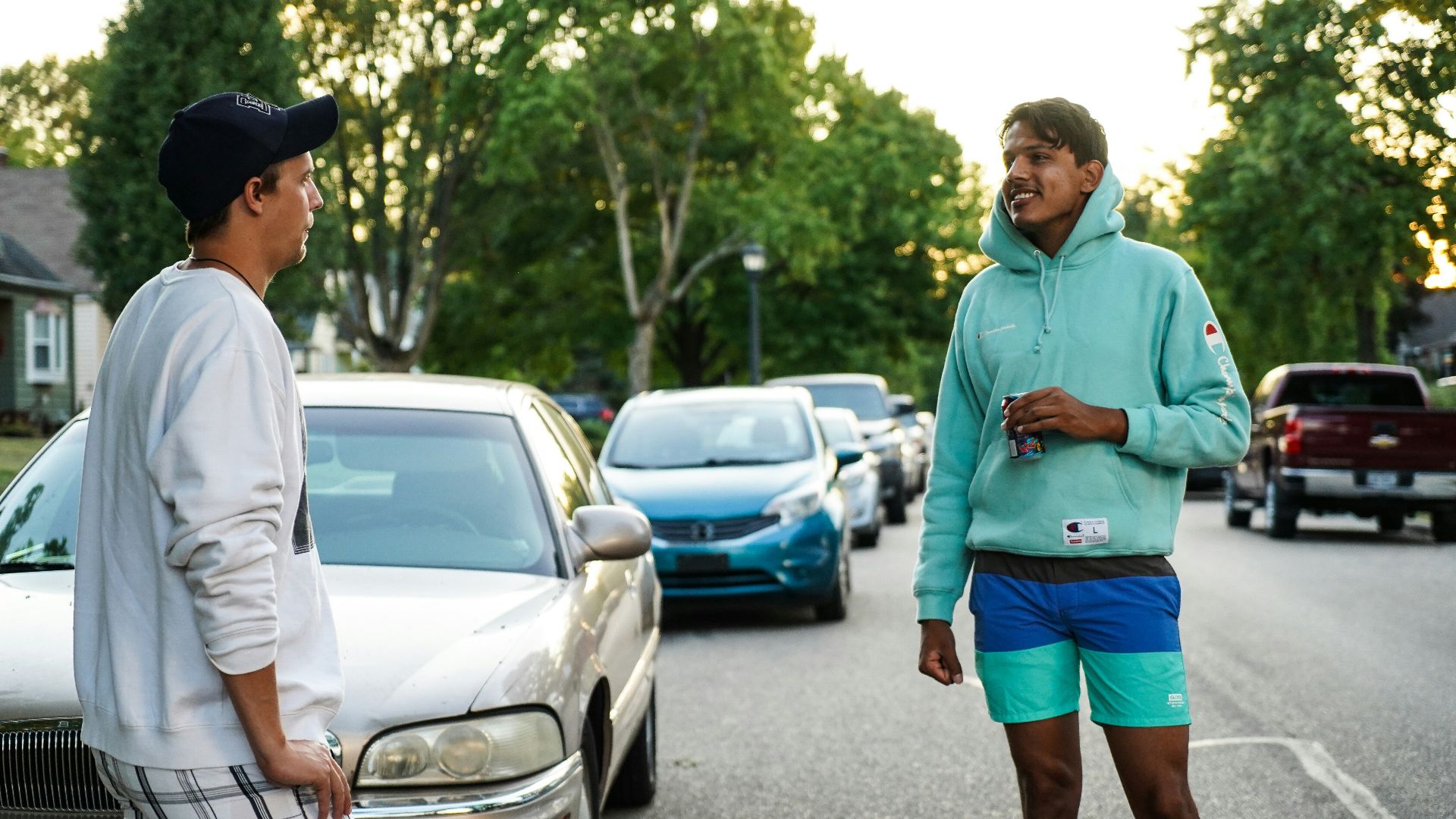 man in green hoodie standing on road during daytime