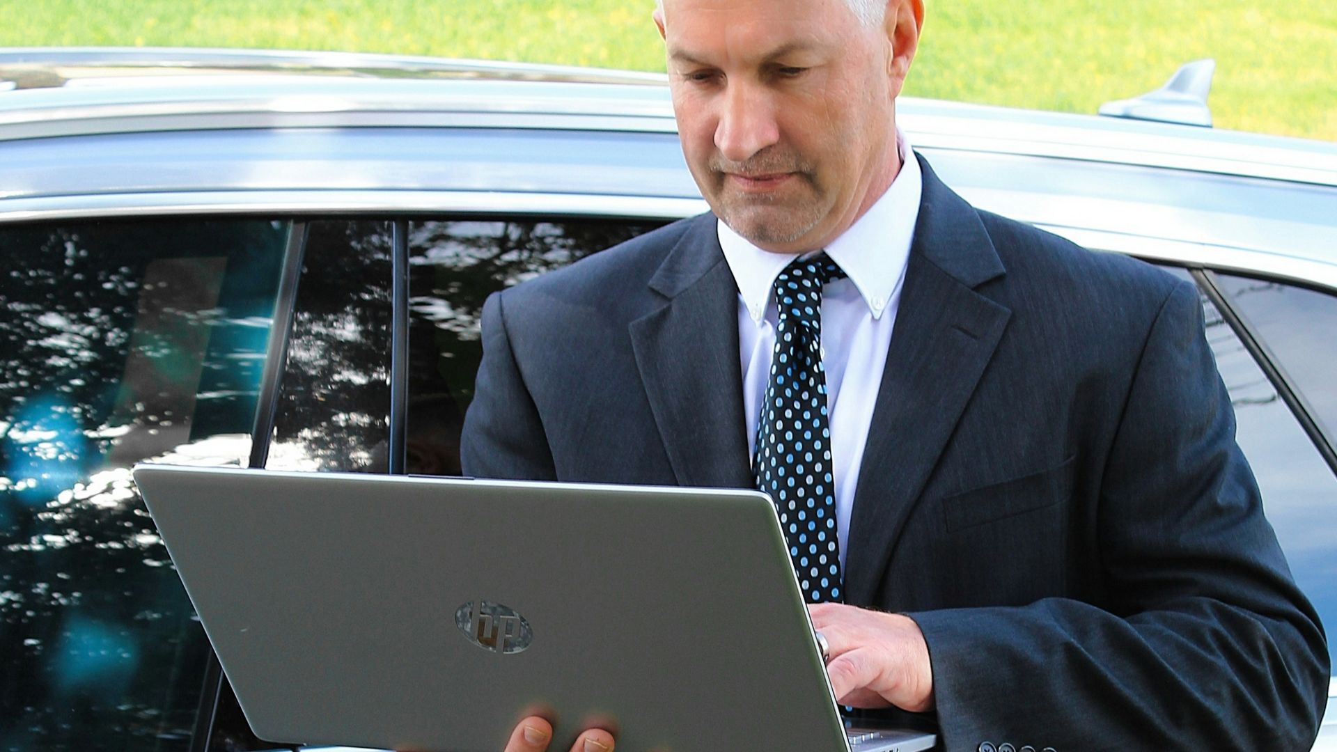 a man in a suit is looking at a laptop