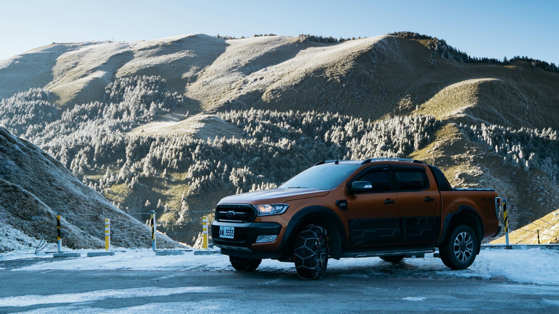 a truck is parked in the snow near a mountain