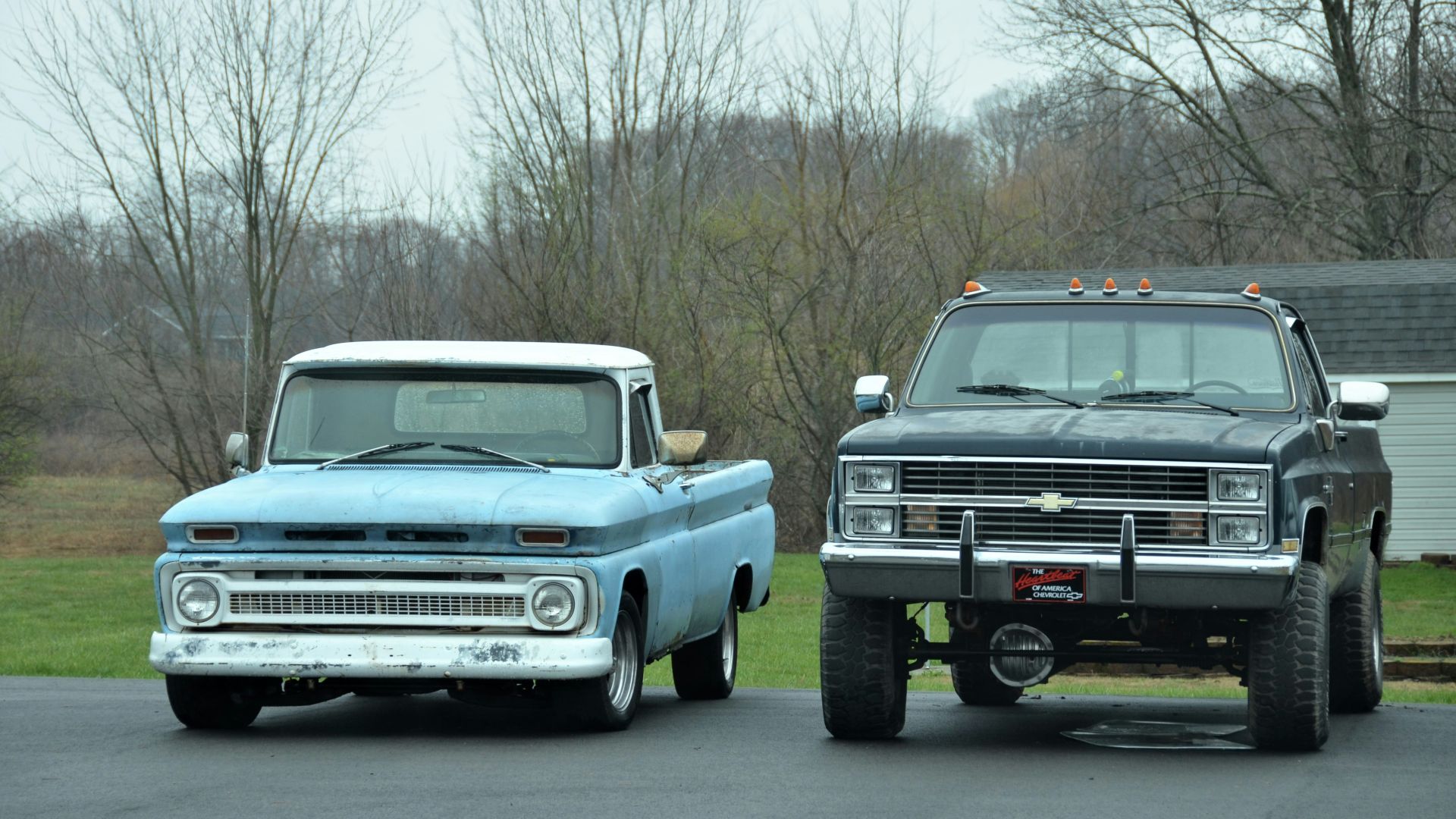 two trucks parked in a parking lot next to each other