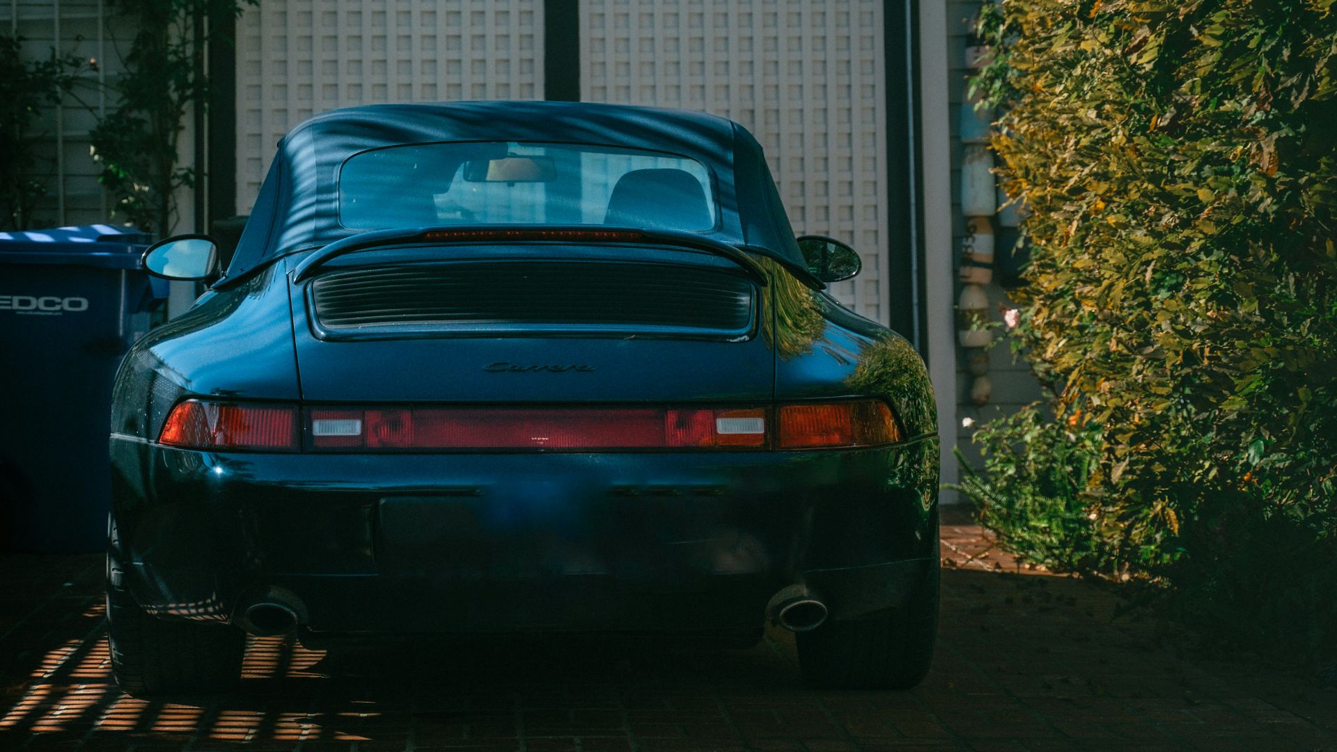 Dark blue sports car parked in front of garage