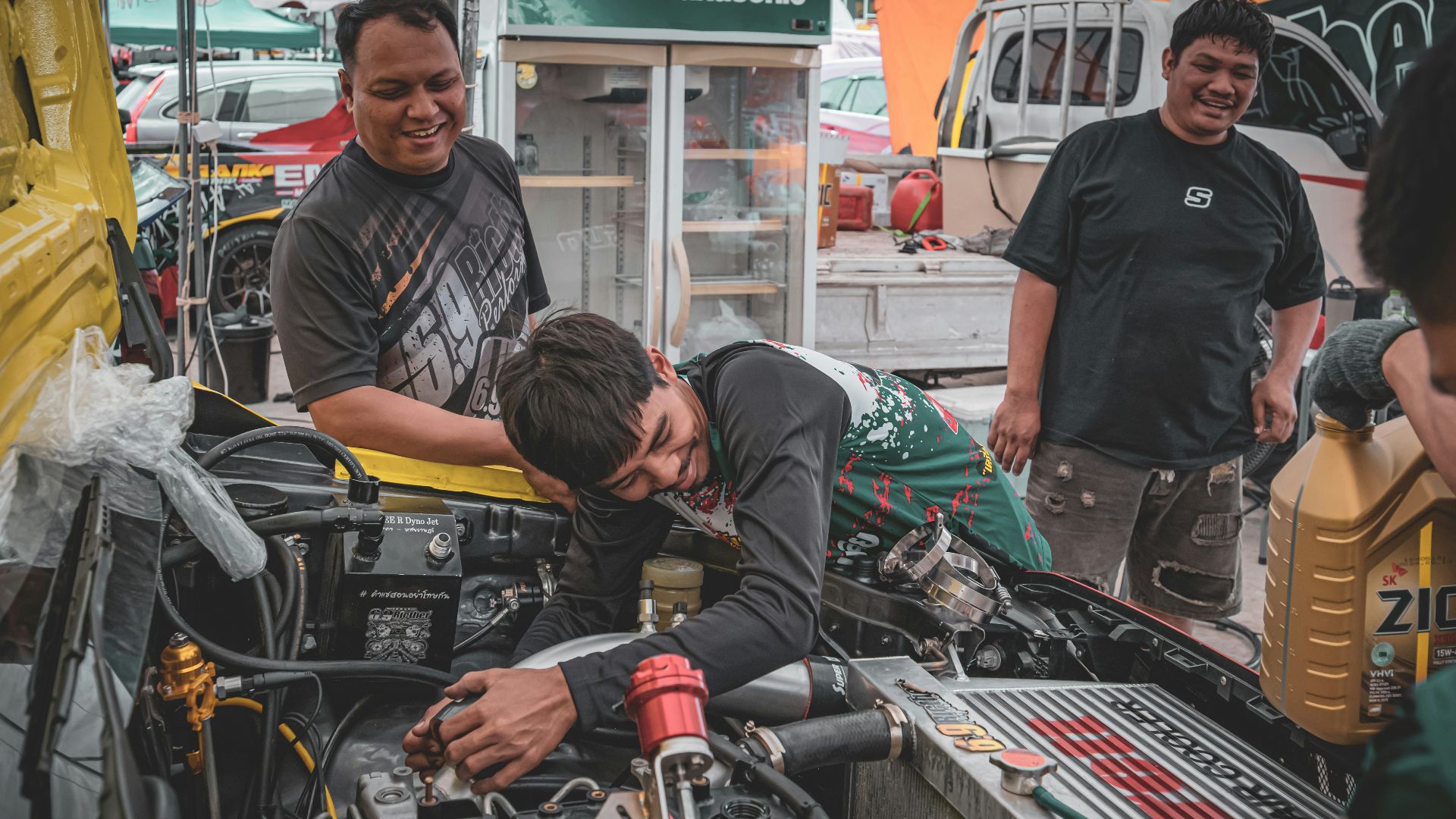 Men working on a car engine outdoors