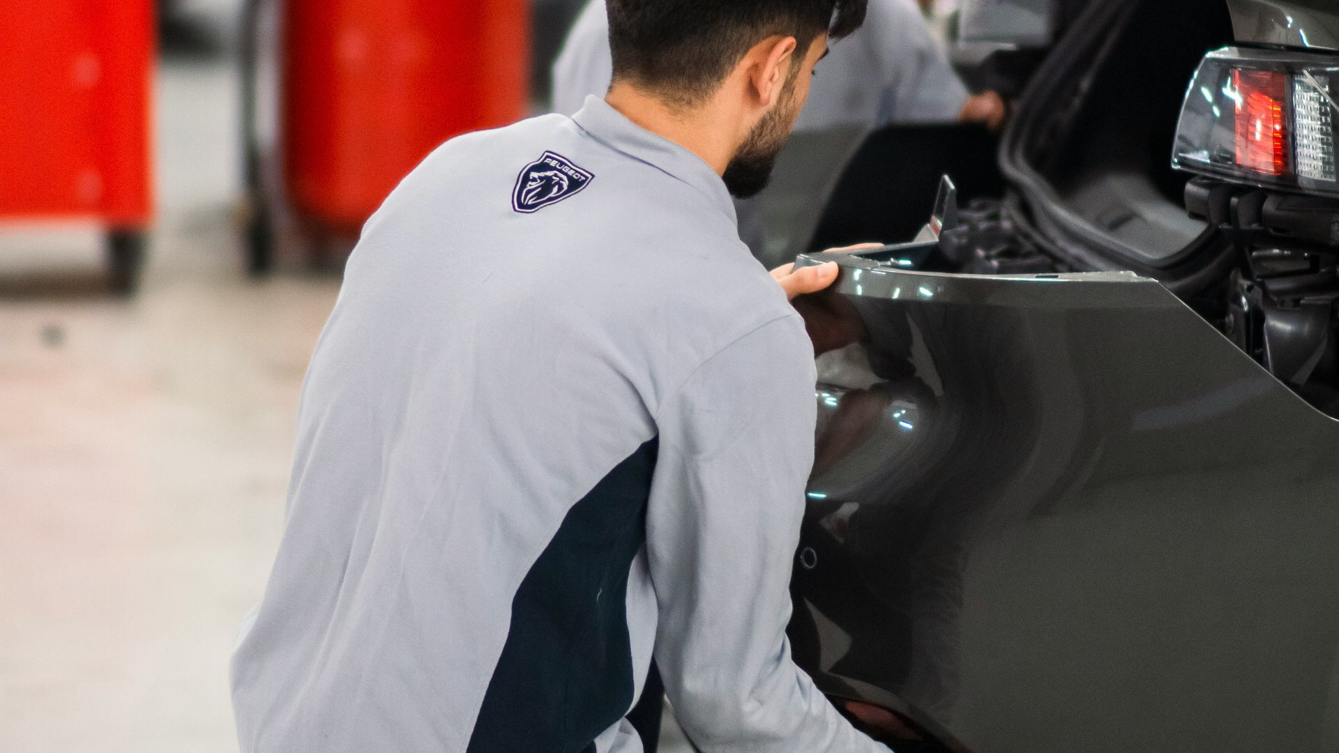 Two men working on a car in a garage