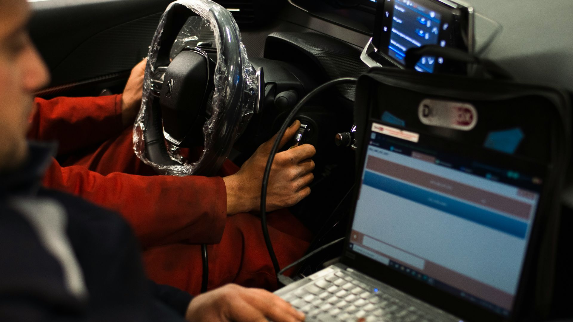 A man sitting in a car using a laptop computer
