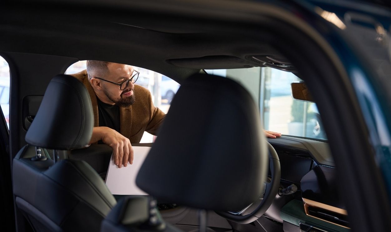 Guy inspects the interior of a new car