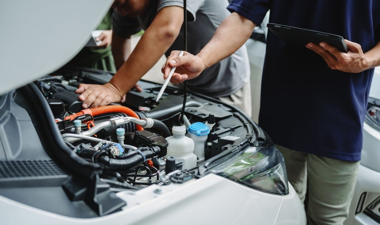Three Asian men discussing car insurance policies with adjuster. They review details such as premiums, deductibles, coverage options while handling recent claim and evaluating the settlement process.