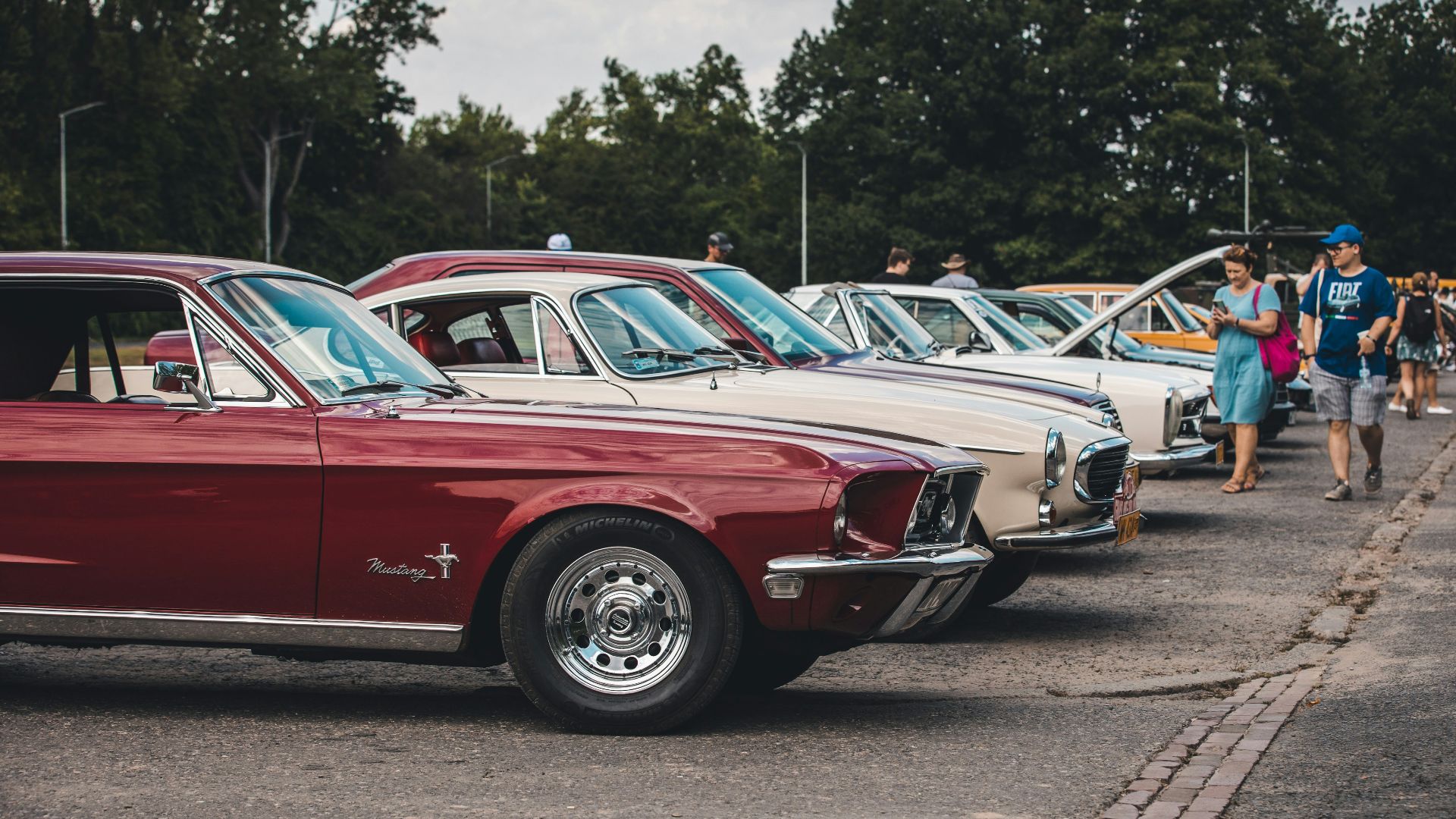 a row of old cars parked in a parking lot