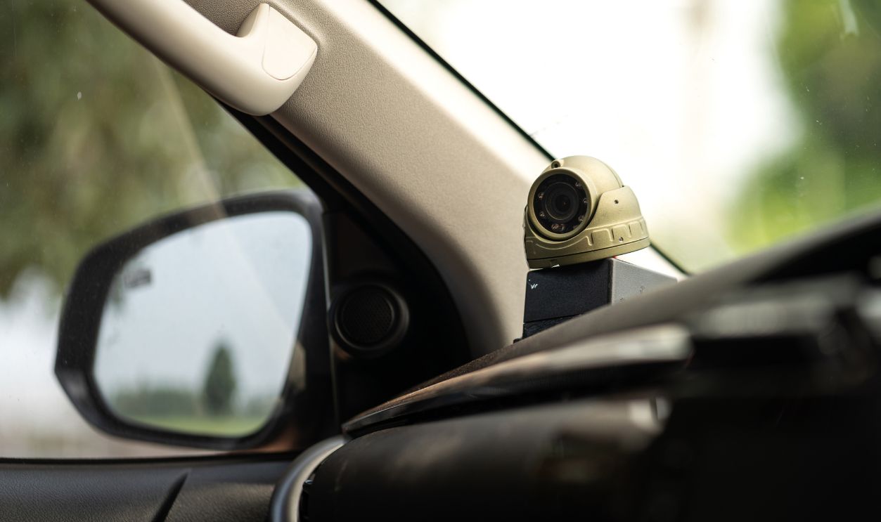 A  camera on car console which is installed for safety reason  to monitor the driver and passenger behavior in company vehicle. Transportation and technology equipment photo. Selective focus.