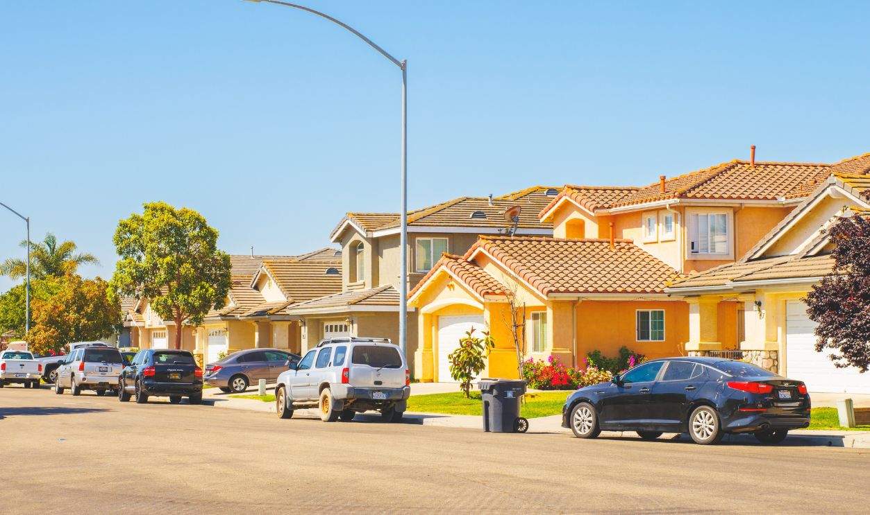 Santa Maria, California, USA - June 11, 2024. Beautiful houses with nicely landscaped front the yard, and cars parked on a sidewalk in small town in California.