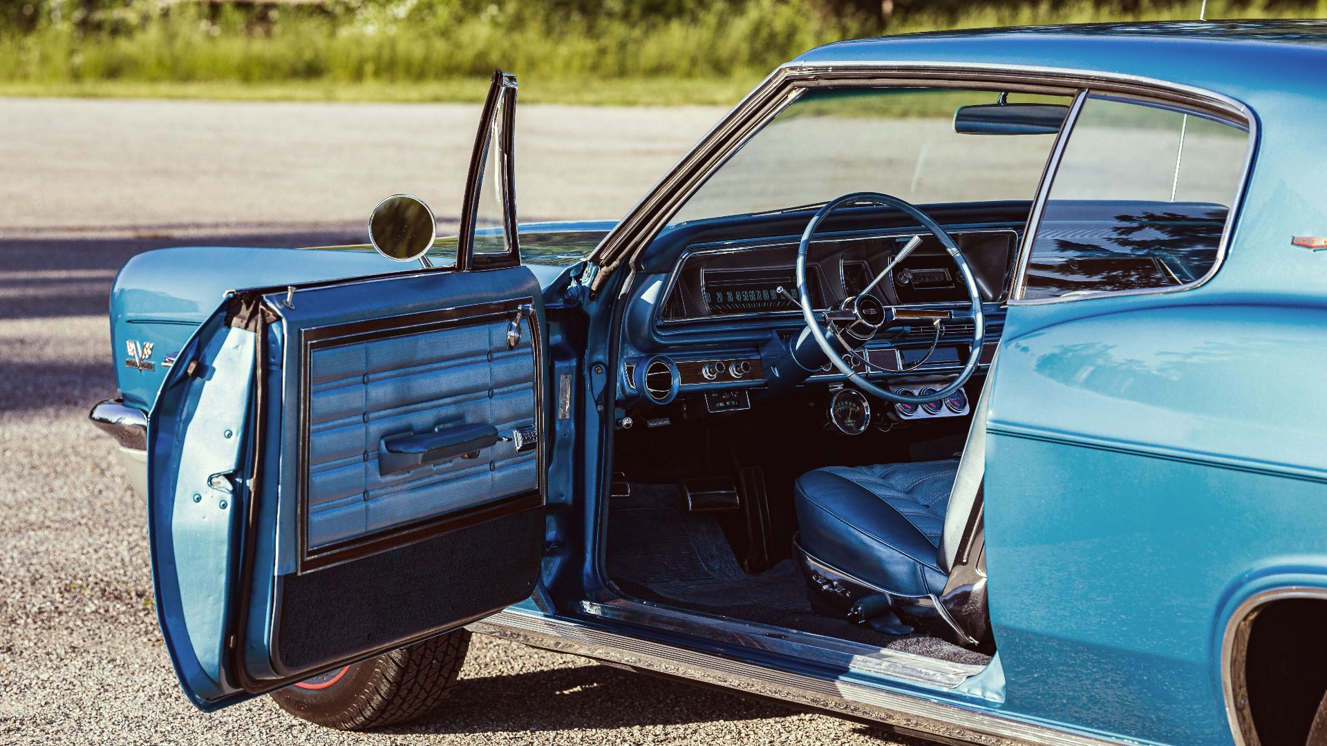 An old blue car with the door open