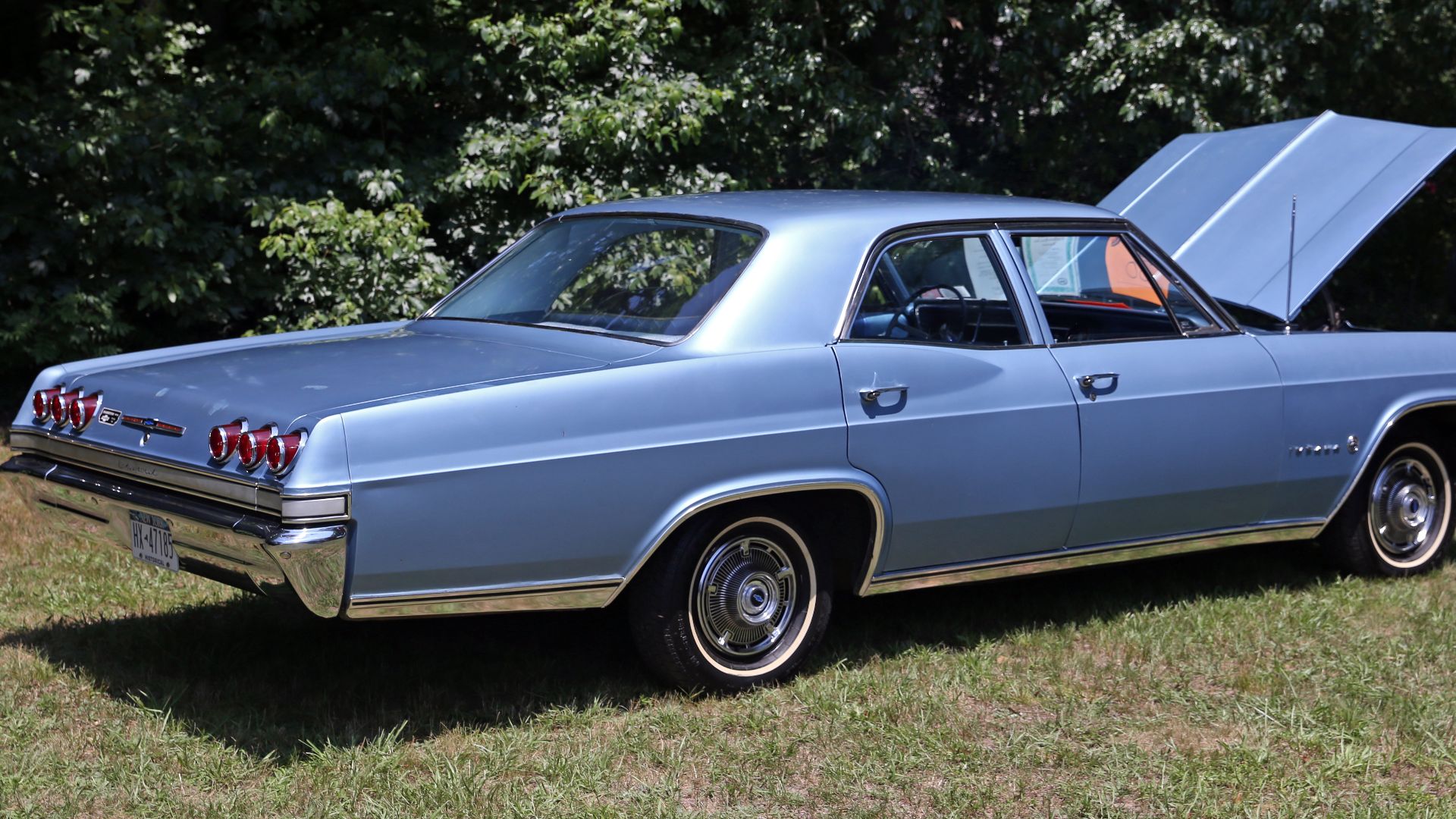 Rear right 3/4 view of a 1965 Chevrolet Impala four-door sedan in Blue Mist (trim B, paint DD). Low mileage, three-owner car with the 283 V8 (195hp) and the optional two-speed Powerglide automatic transmission, Posi-Traction rear, power steering, seat bel