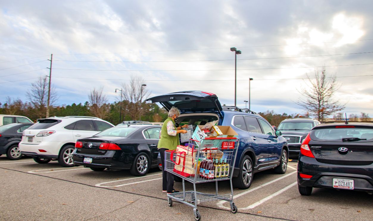 Augusta, Ga USA 01 07 21: Senior putting groceries in her car wearing a face mask side view