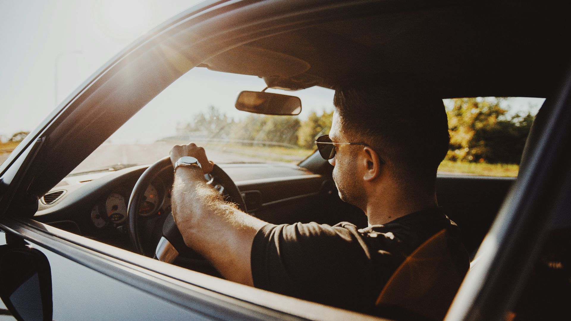 man in black jacket driving car during daytime