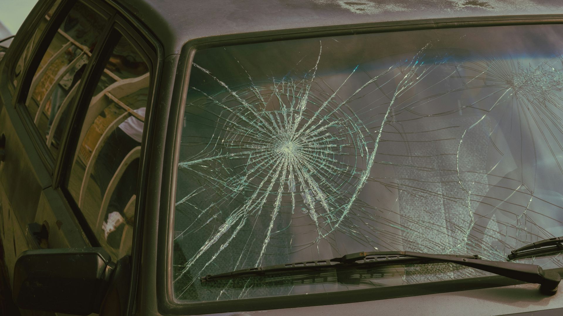 A broken windshield of a car with a broken windshield