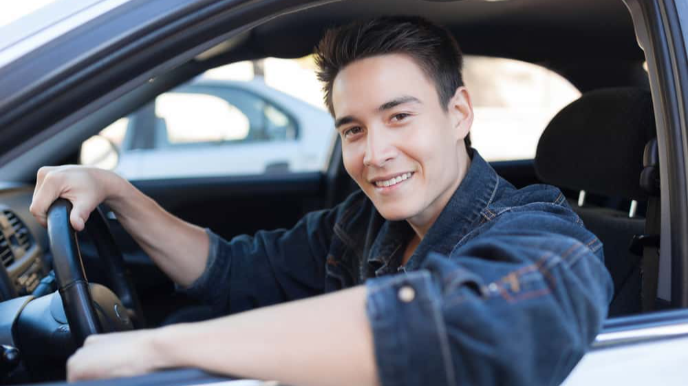 Happy young man sitting in the car
