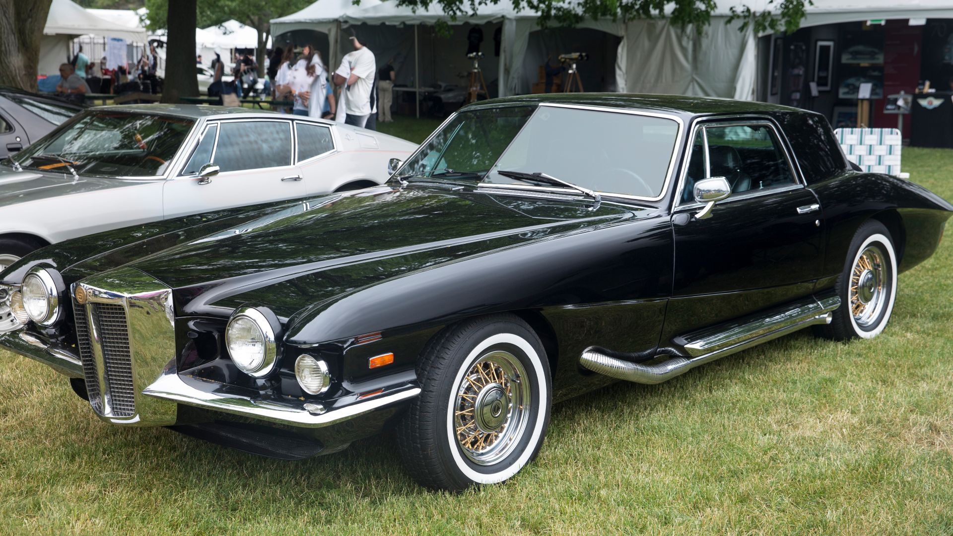 A 1971 Stutz Blackhawk Series I in Masons Black seen at the 2023 Greenwich Concours d'Elegance. First example built and first sold to Elvis Presley. Frank Sinatra also wanted it but Elvis agreed to use his likeness in some photos of it and Stutz chose to 