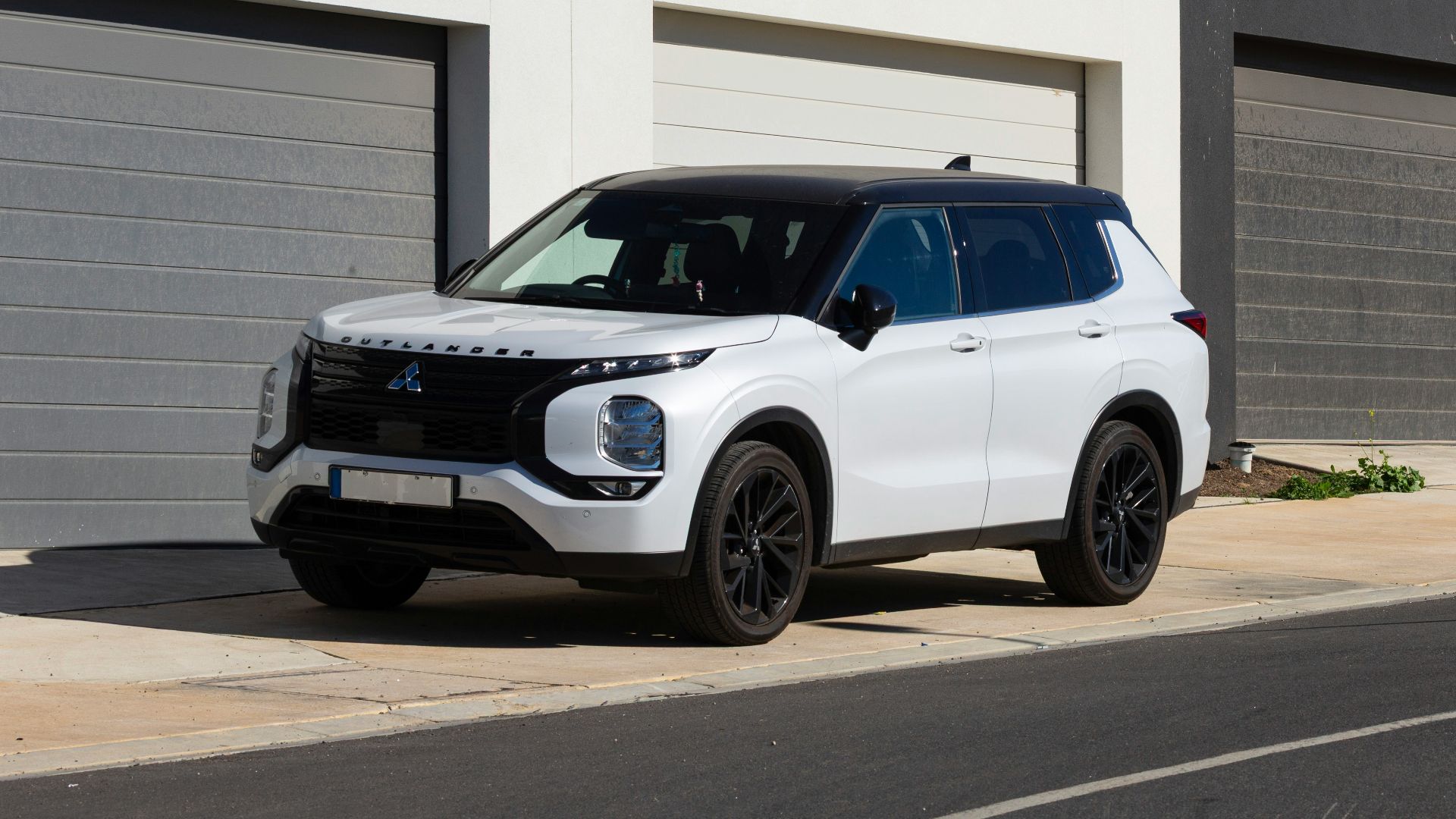 White suv parked in front of modern garages