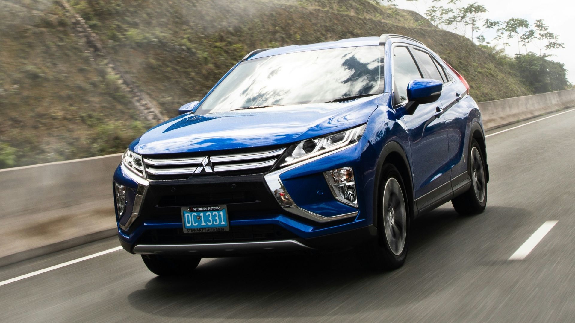 a blue car driving on a road