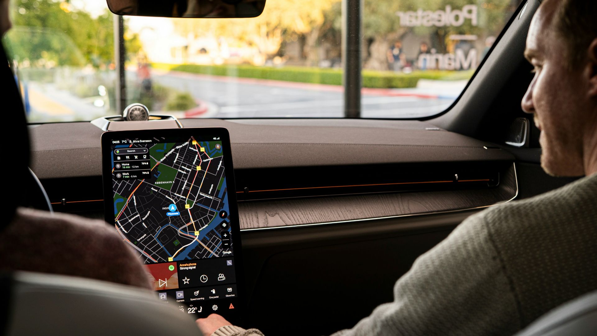 a man sitting in a car holding a tablet