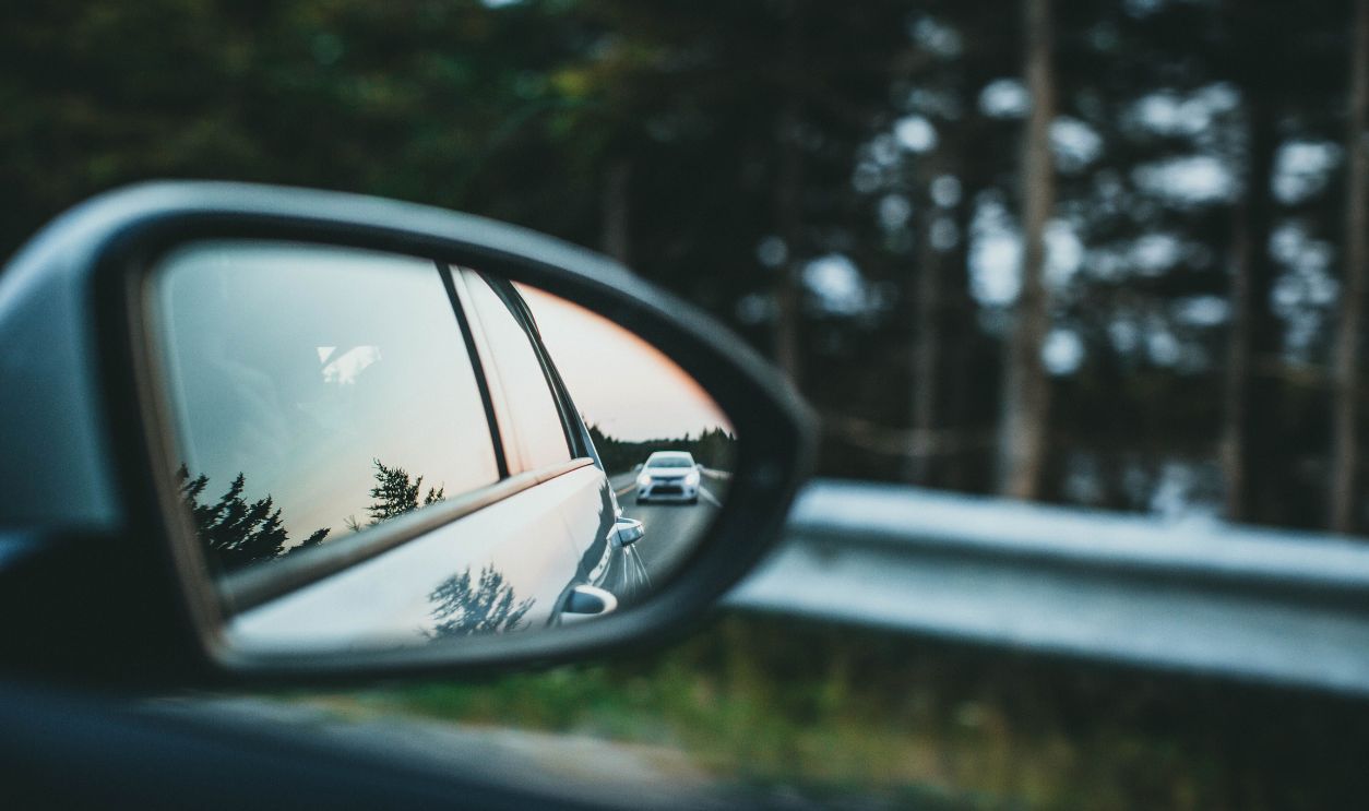 A car is reflected in a side mirror