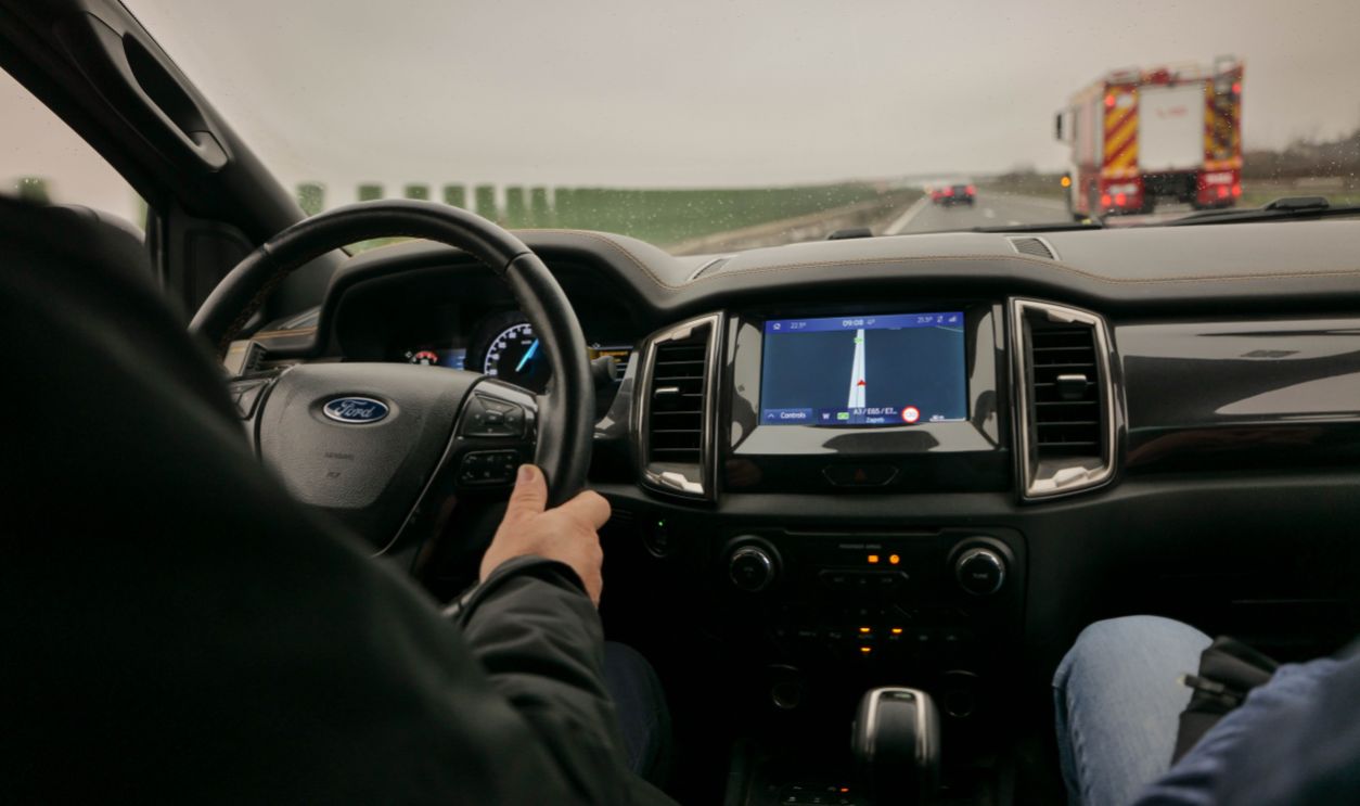 Interior view of driving a Ford with navigation system on a highway
