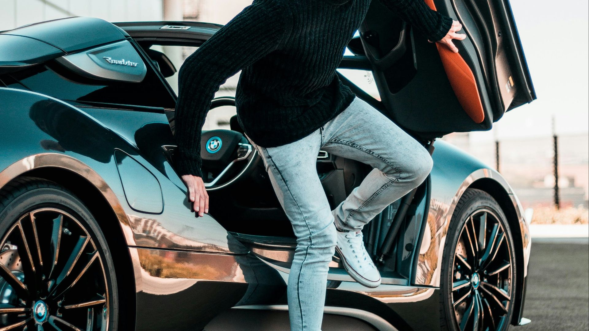 a man standing next to a car with its doors open