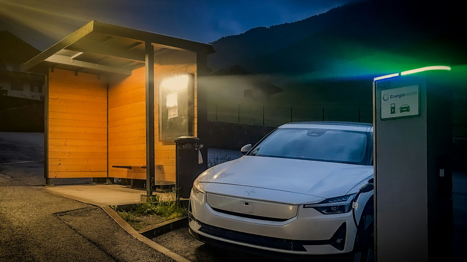 Electric car charging at a station at night.