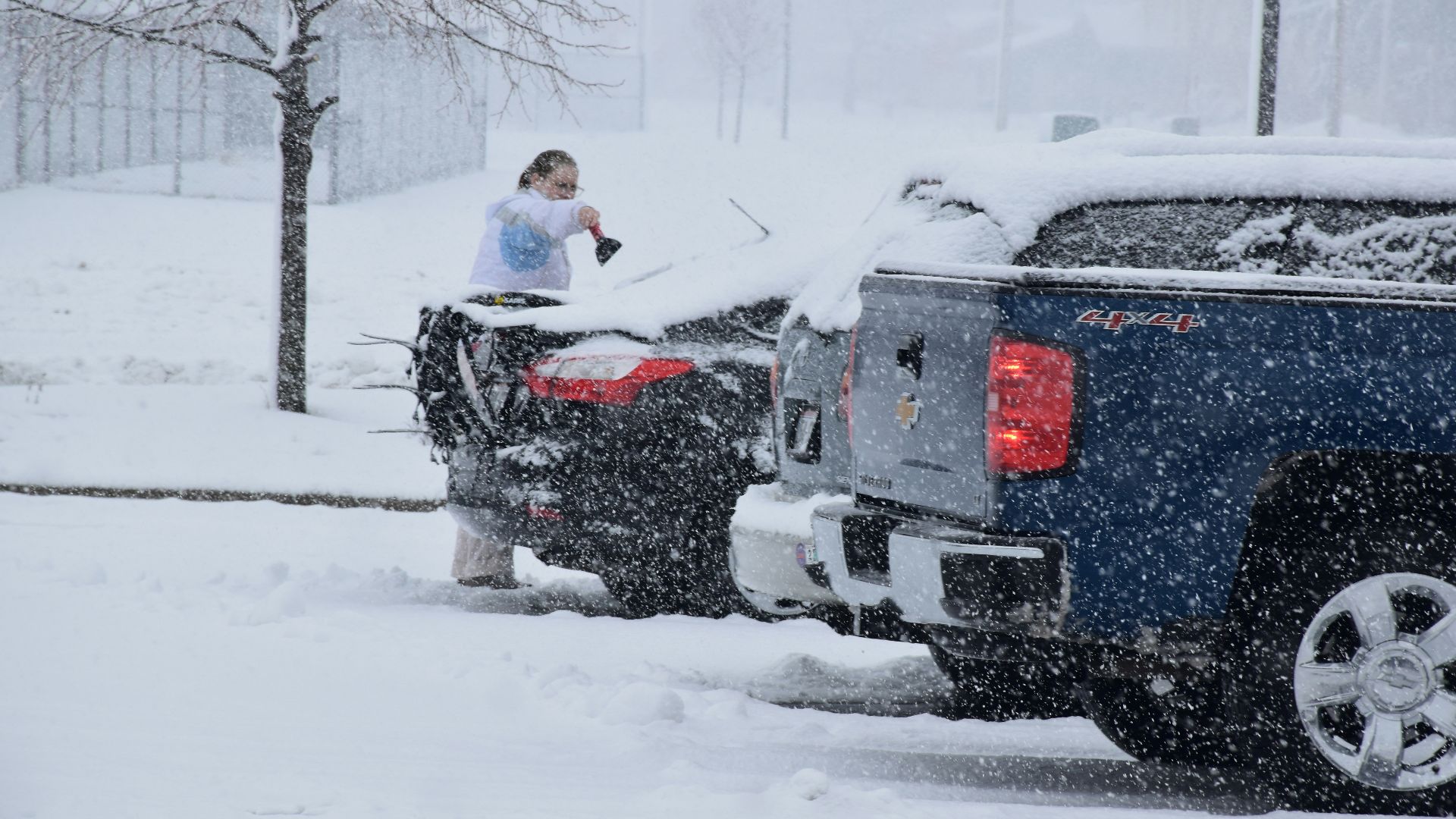 a woman standing on top of a truck in the snow