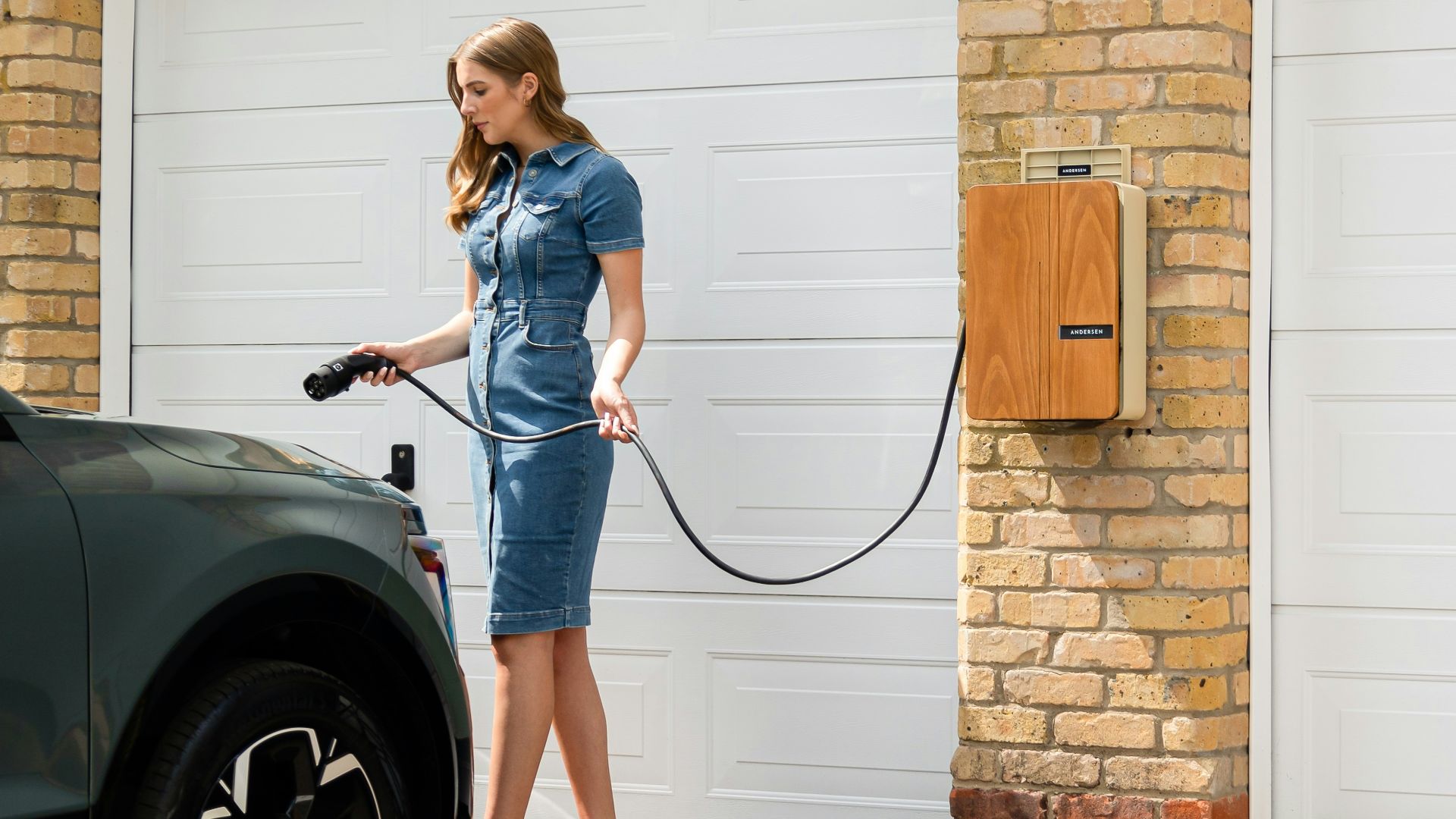 A woman in a blue dress is washing a car