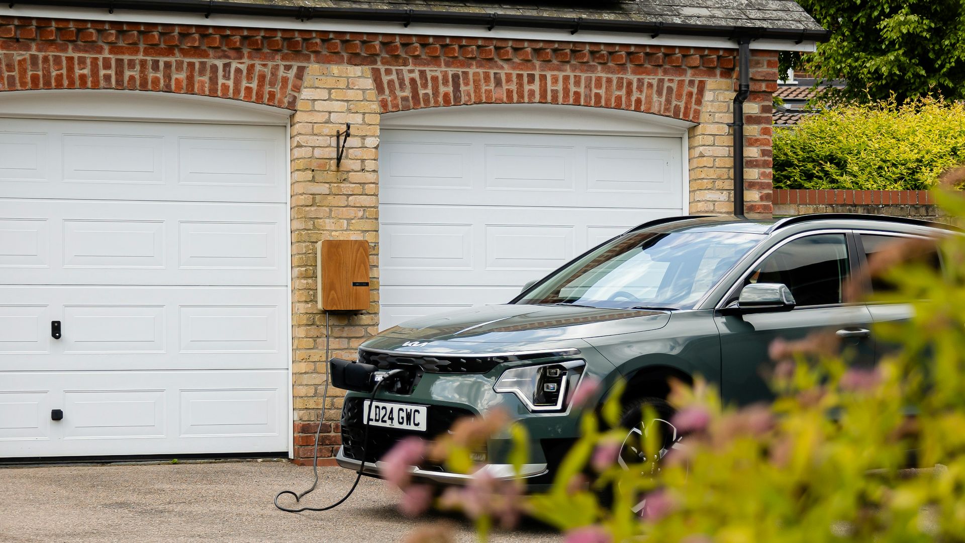 A car parked in front of a house with a solar panel on the roof