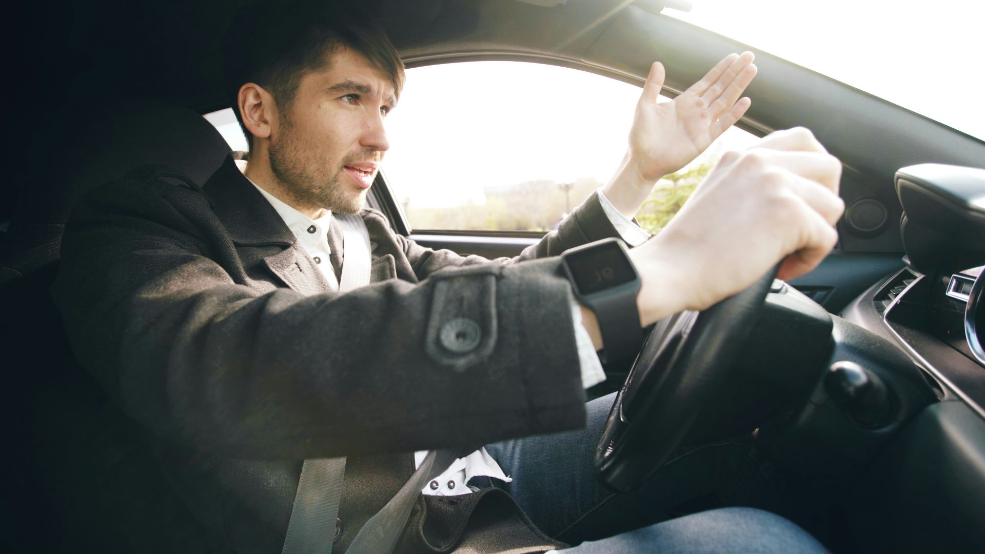 Man driving a car, gesturing with hand