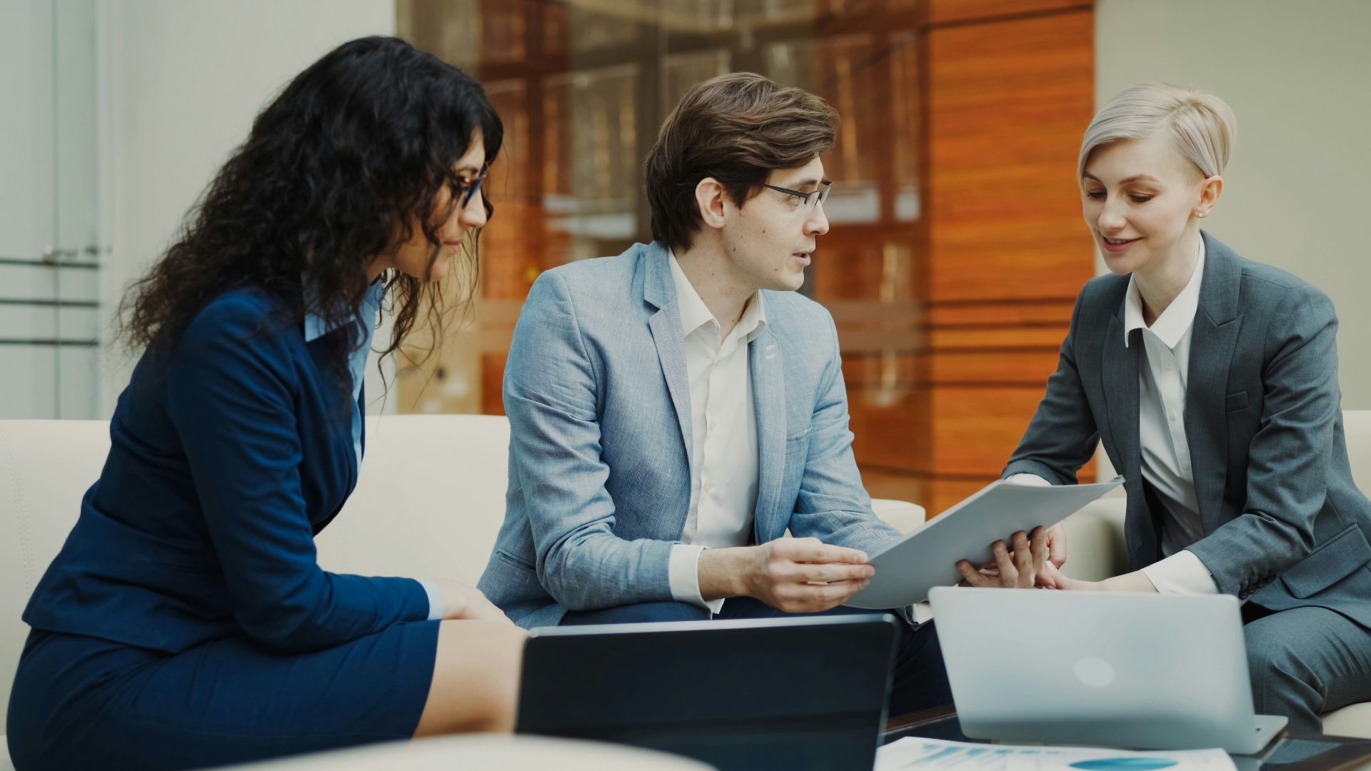 Three professionals discussing documents at a table