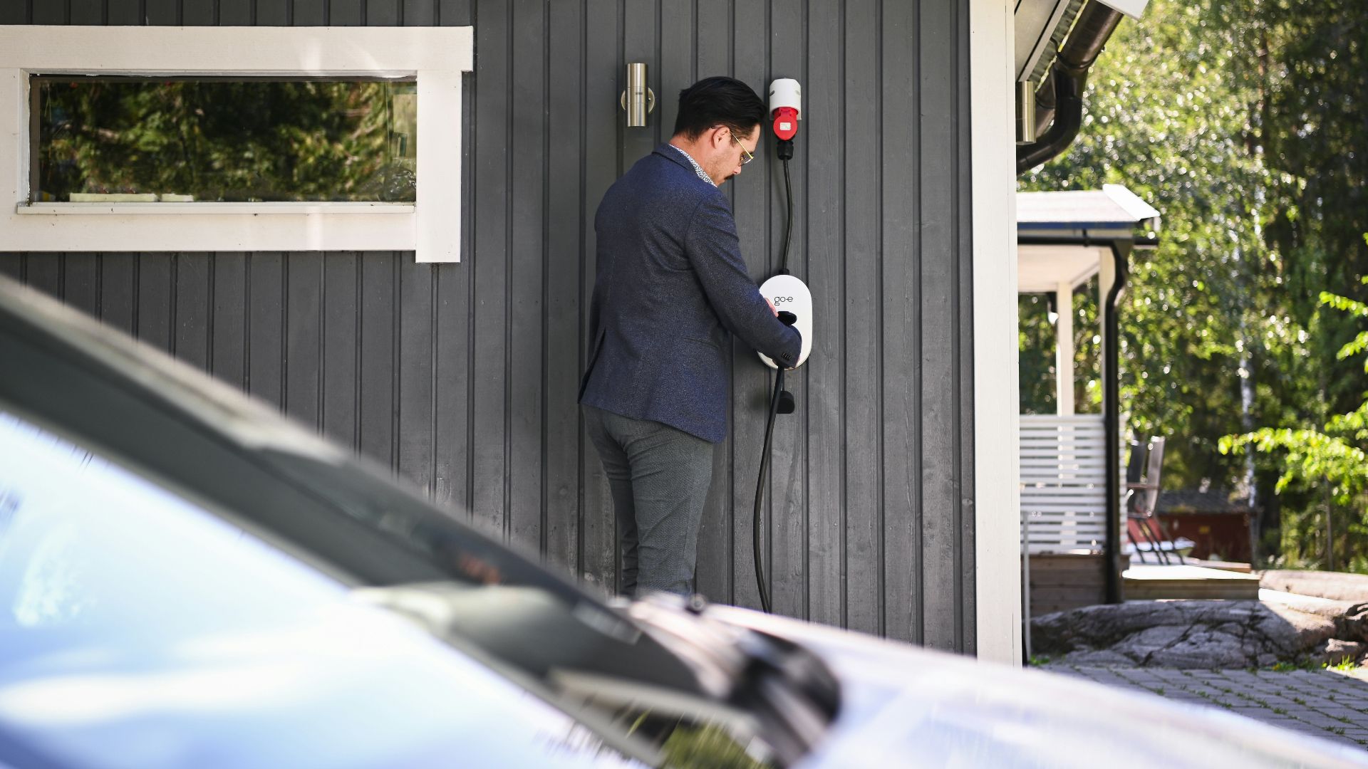 Man plugs in an electric vehicle charging cable