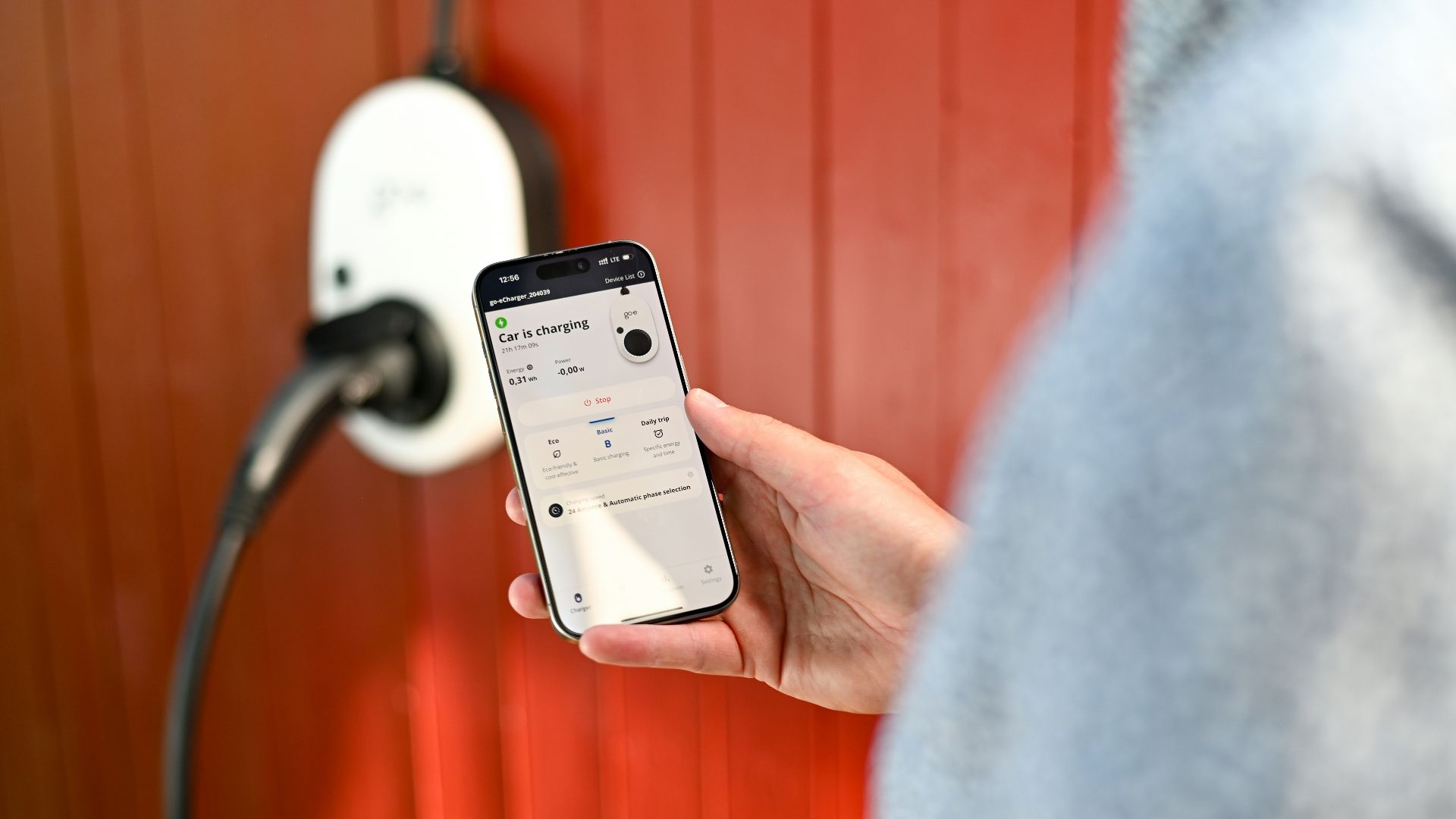 Person uses phone to control electric vehicle charger